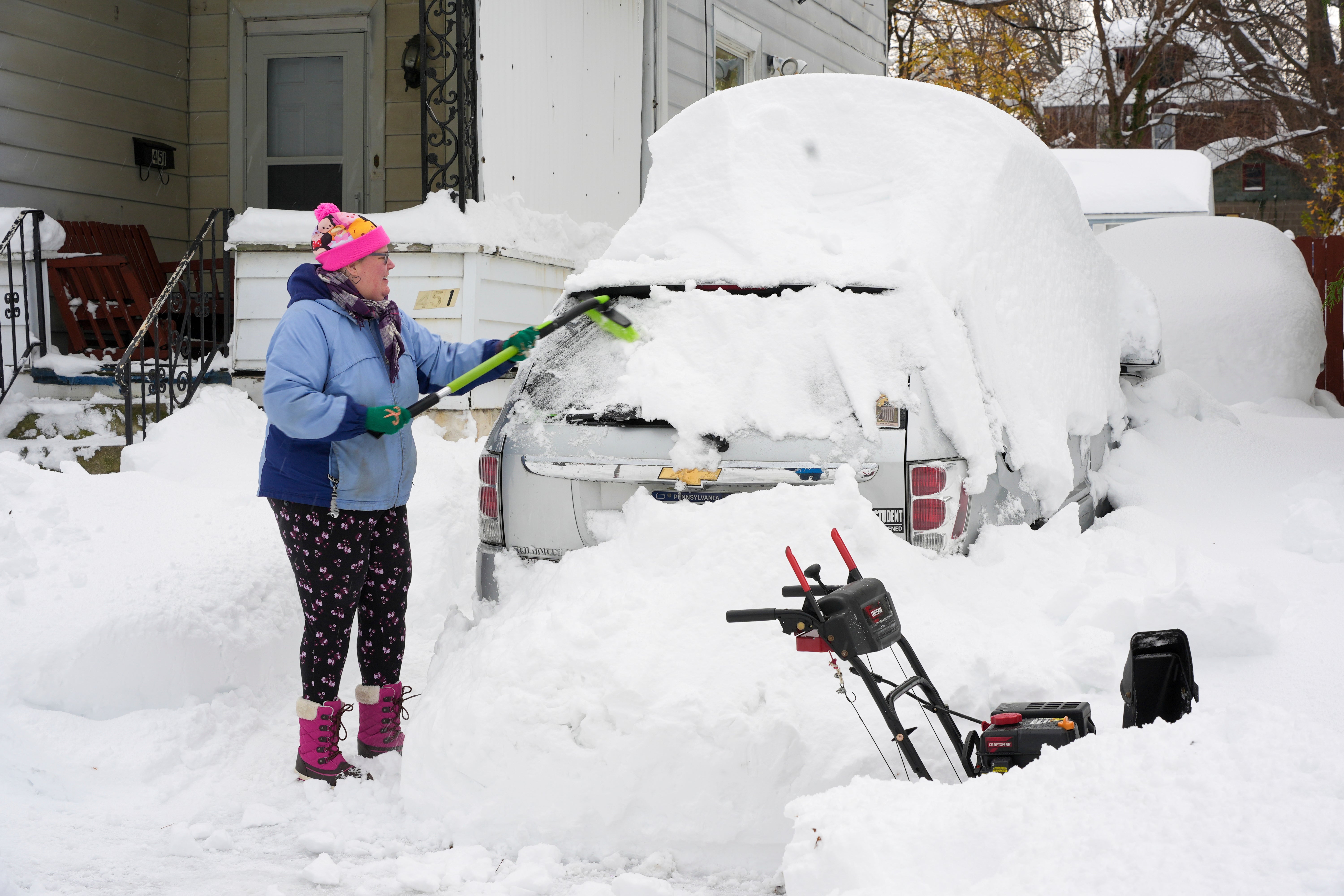 Serena Schodt brushes snow off her car in Erie, Pennsylvania, on Monday. Winter storm warnings and advisories were posted through Tuesday in Michigan, and lake-effect snow warnings were in effect through Tuesday night in parts of Ohio, New York and Pennsylvania