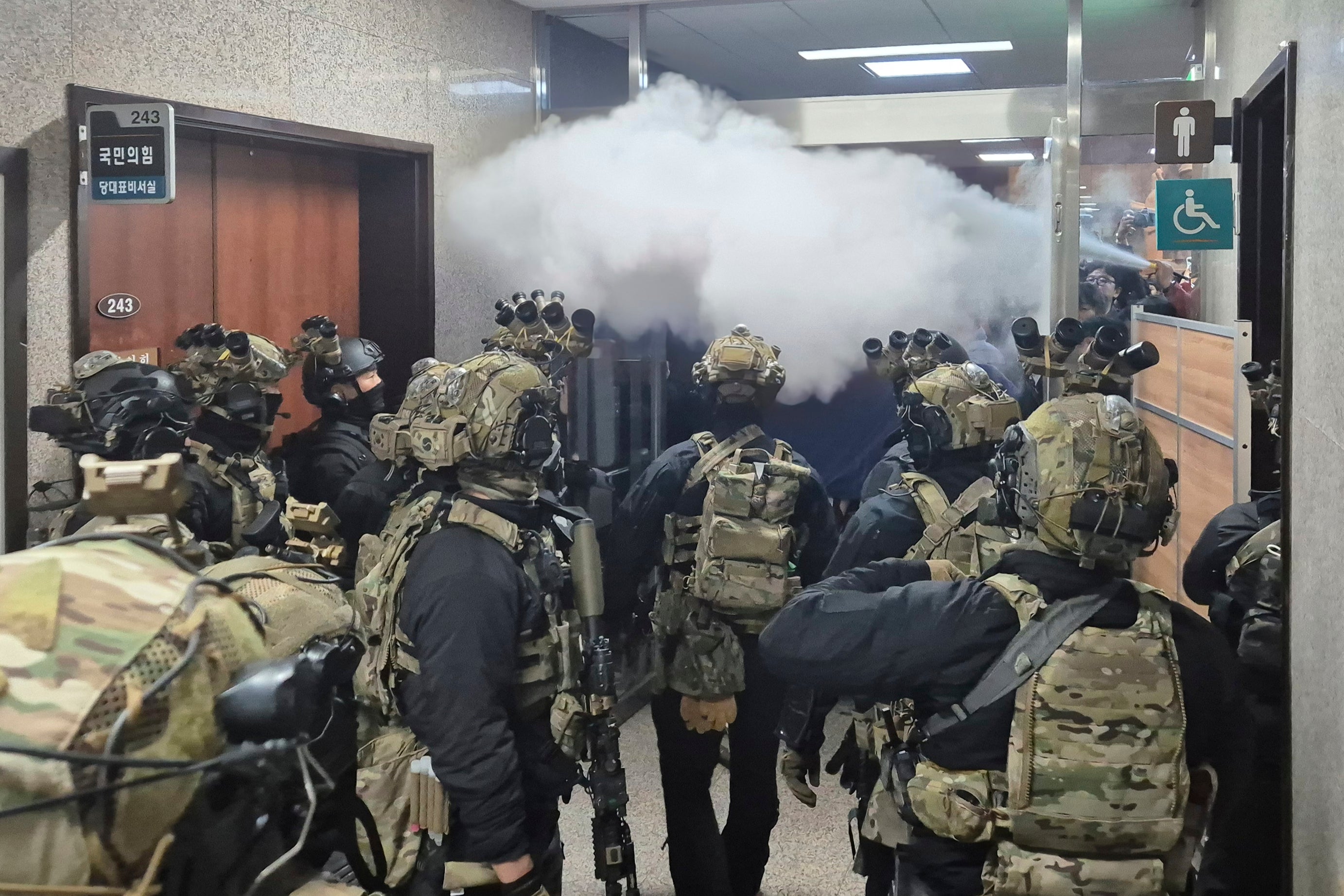 National Assembly employees spray a fire extinguisher towards soldiers at the National Assembly in Seoul, South Korea