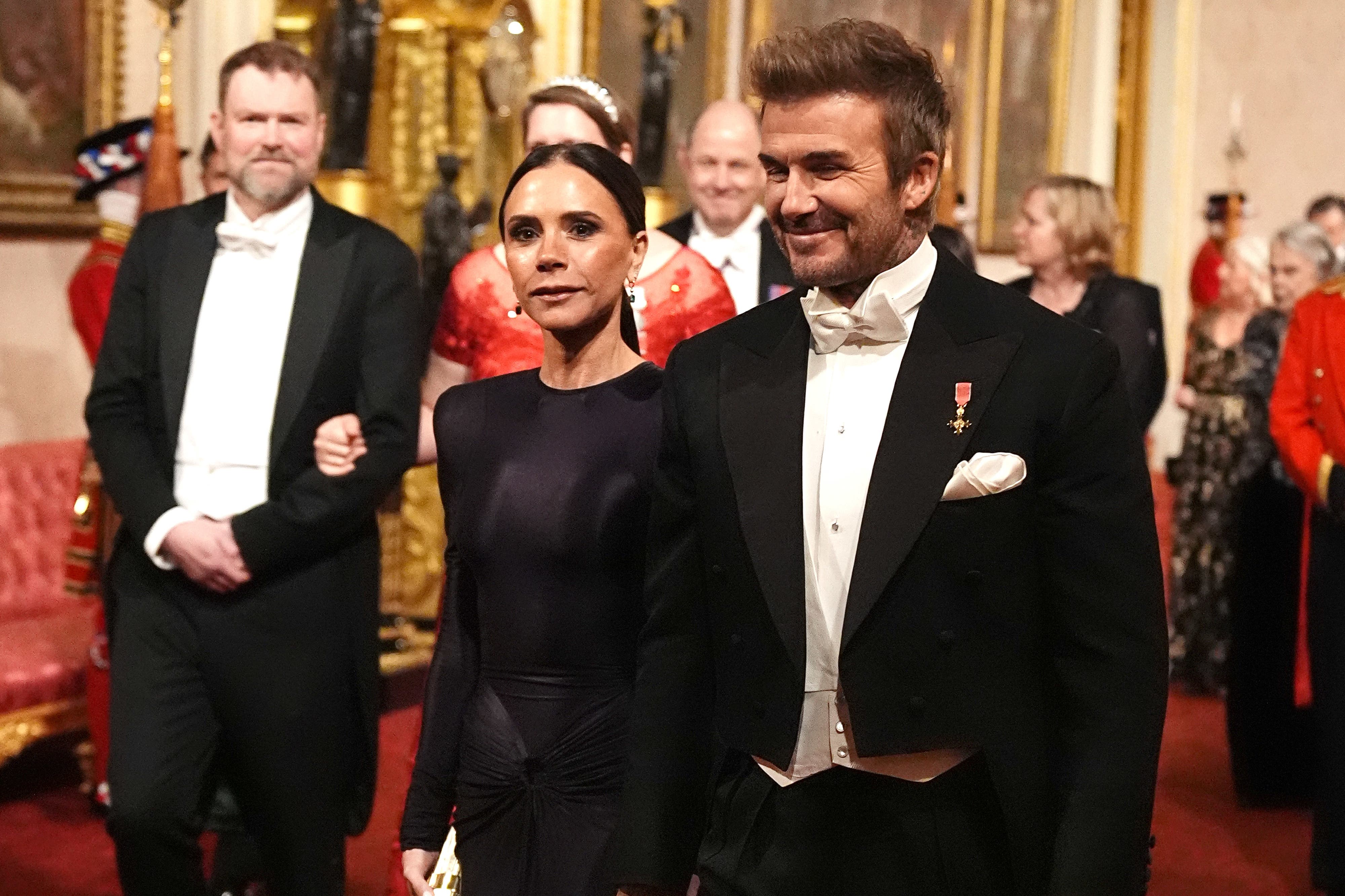 David and Victoria Beckham make their way along the East Gallery to attend the state banquet (Aaron Chown/PA)