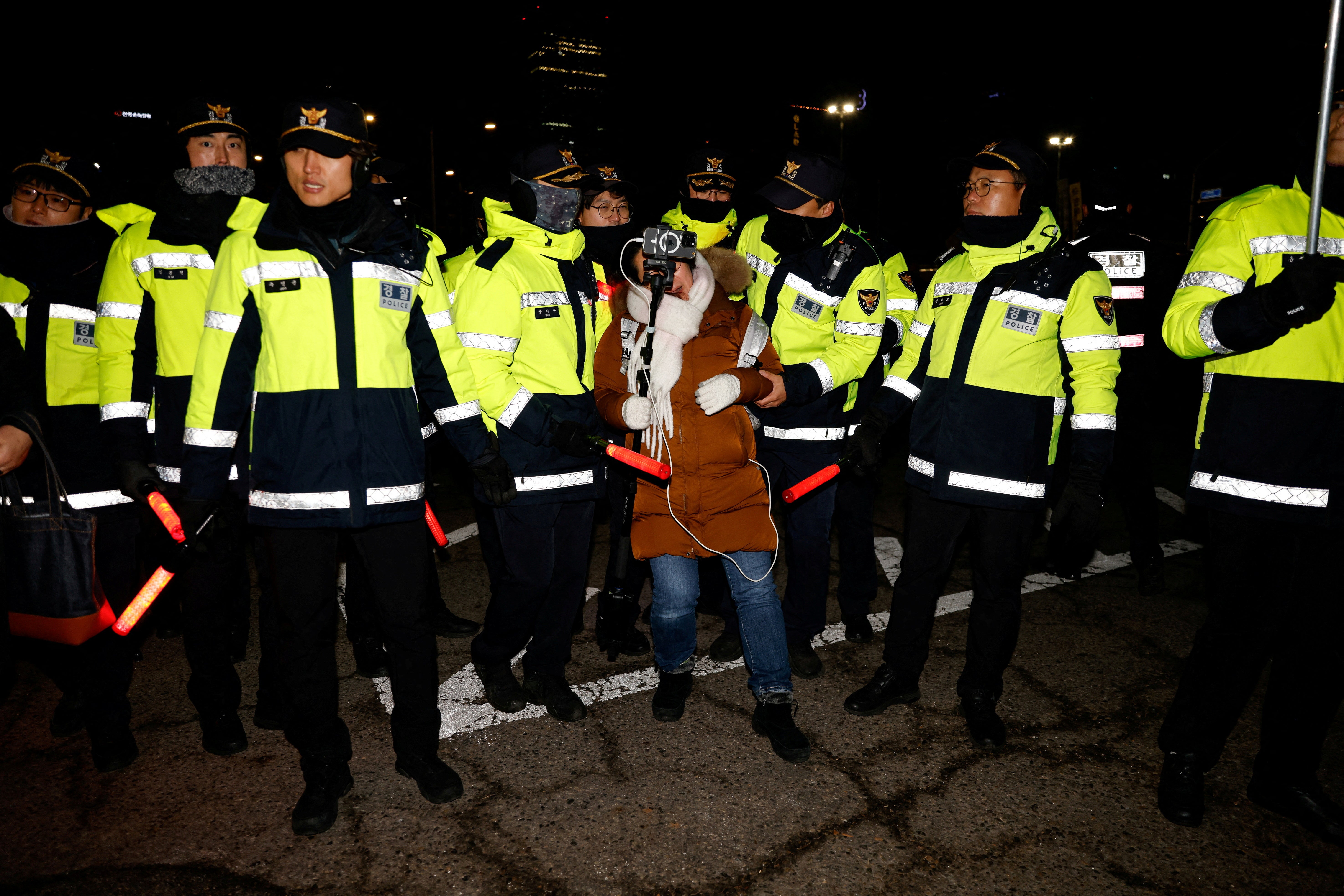 A woman reacts among police officers during a protest outside the National Assembly after president Yoon Suk Yeol declared martial law