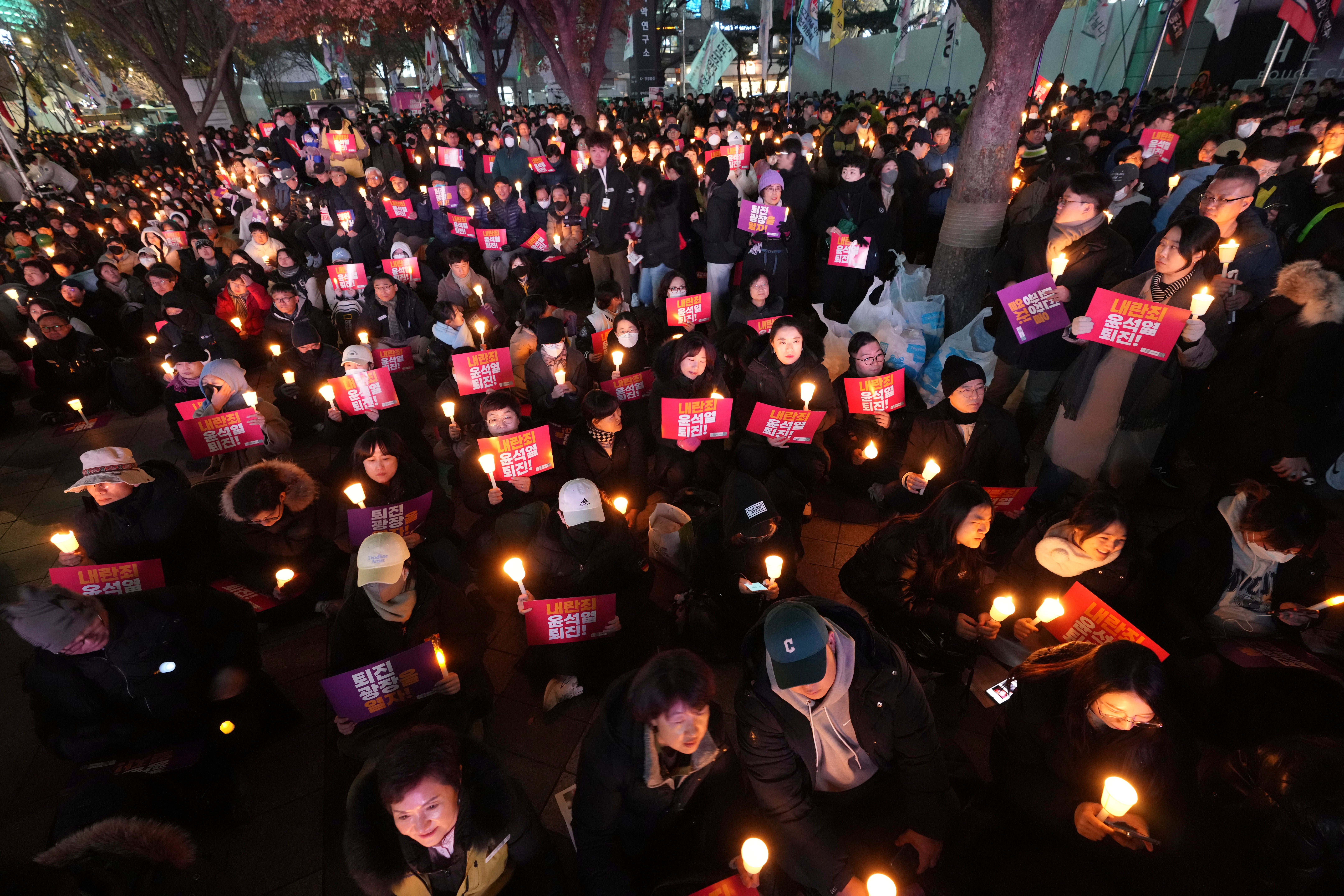 People hold candles during a candlelight vigil against South Korean President Yoon Suk Yeol in Seoul, South Korea, Wednesday, 4 Dec 2024