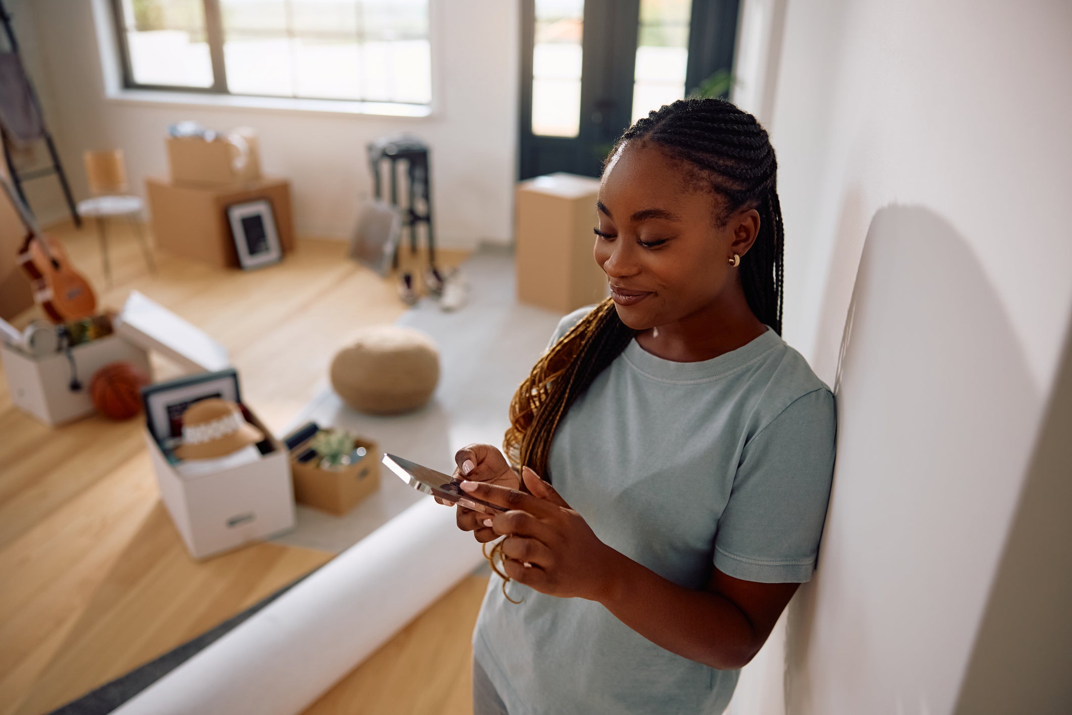 A woman uses a cellphone in her new house. While this study did not include women homeowners, further research will examine the link between homeownership on their life expectancy