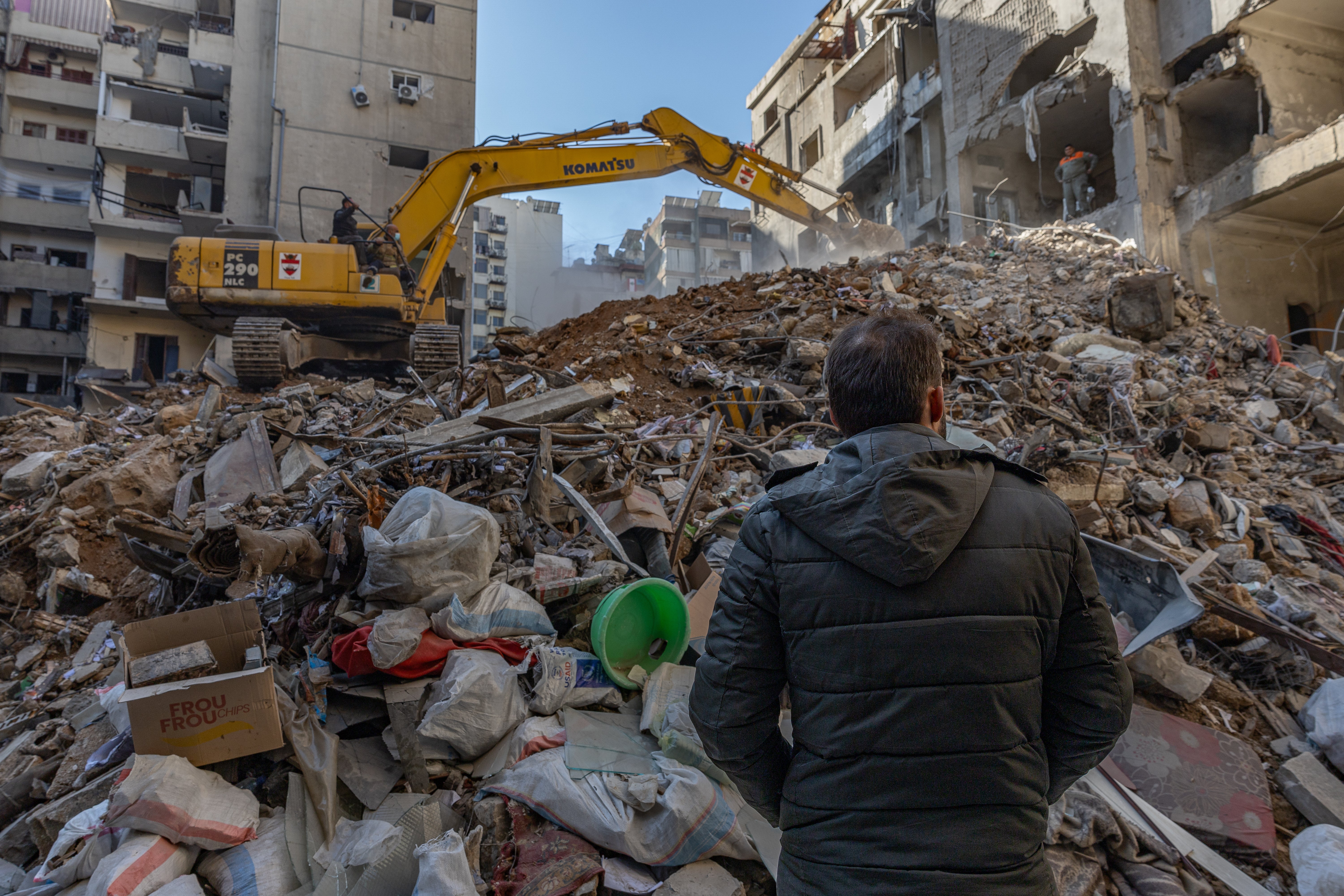 Syrian refugee Ahmad stands in front of a destroyed building in Beirut – his family fled to Syria and are now trapped on the front line