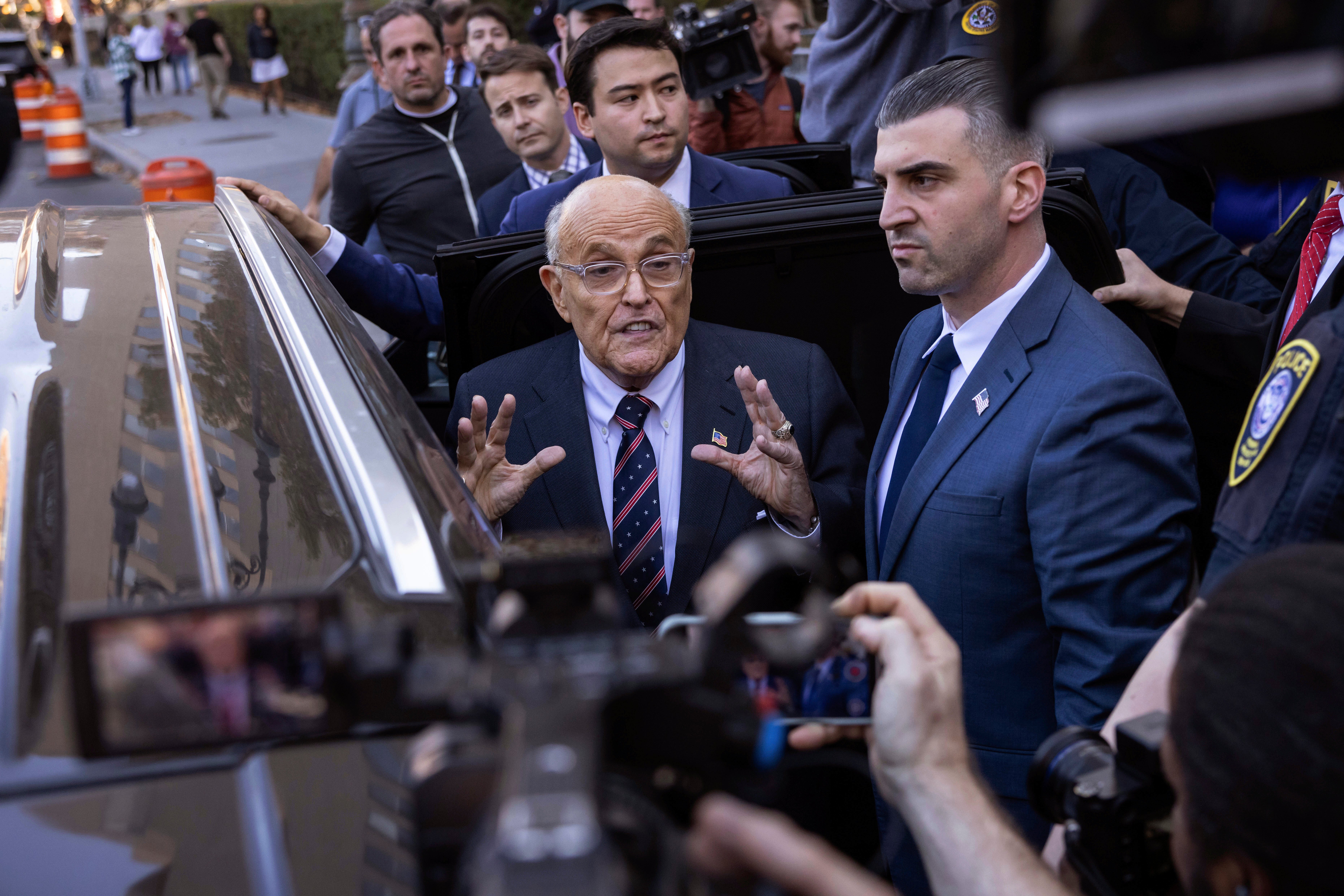 Rudy Giuliani speaks to reporters on November 7 after leaving a federal courthouse in Manhattan, where a judge is enforcing a court order forcing him to turn over property to women he defamed