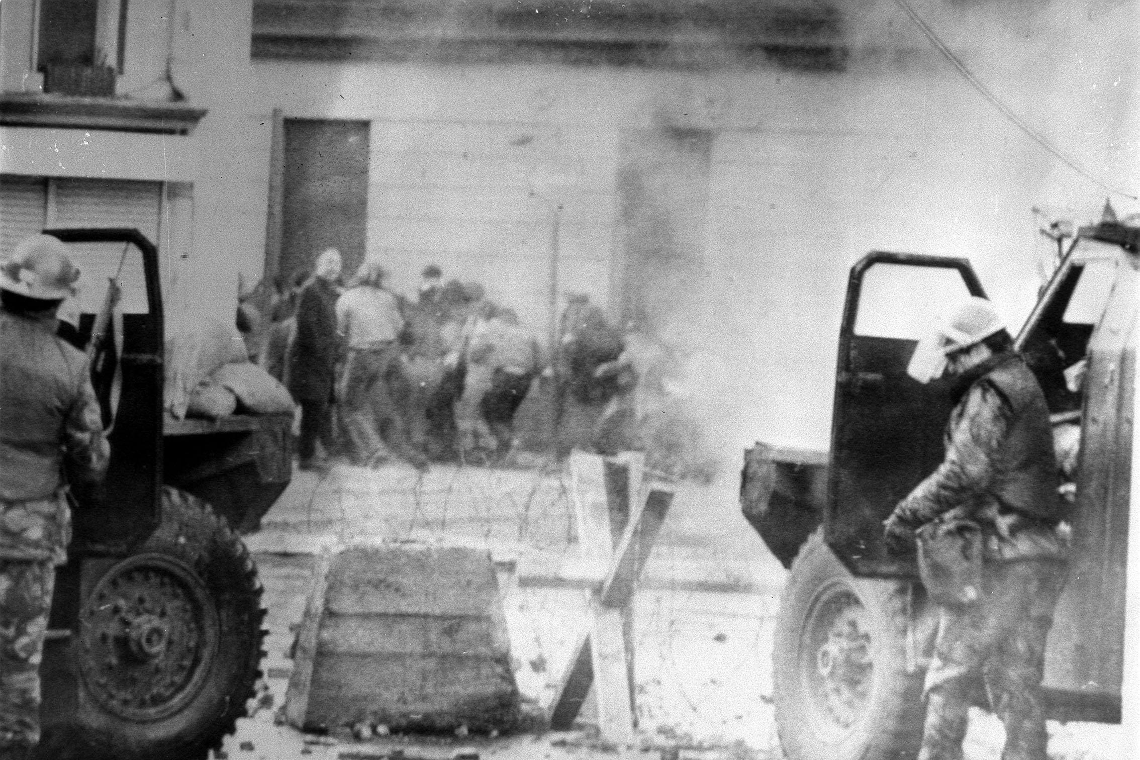 Soldiers take cover behind their armoured cars in Londonderry (PA)