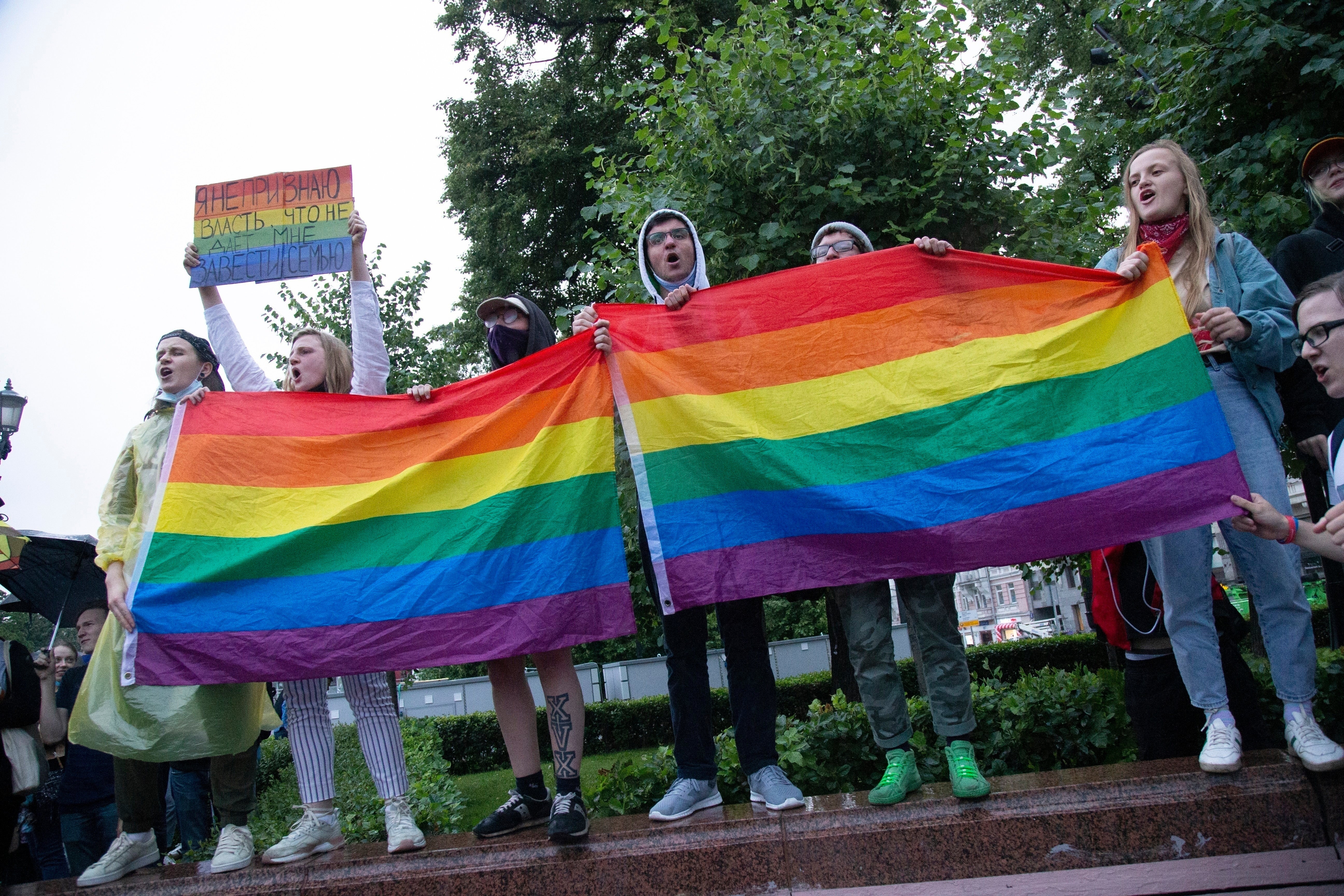 LGBTQ+ activists wave flags at a rally in Moscow