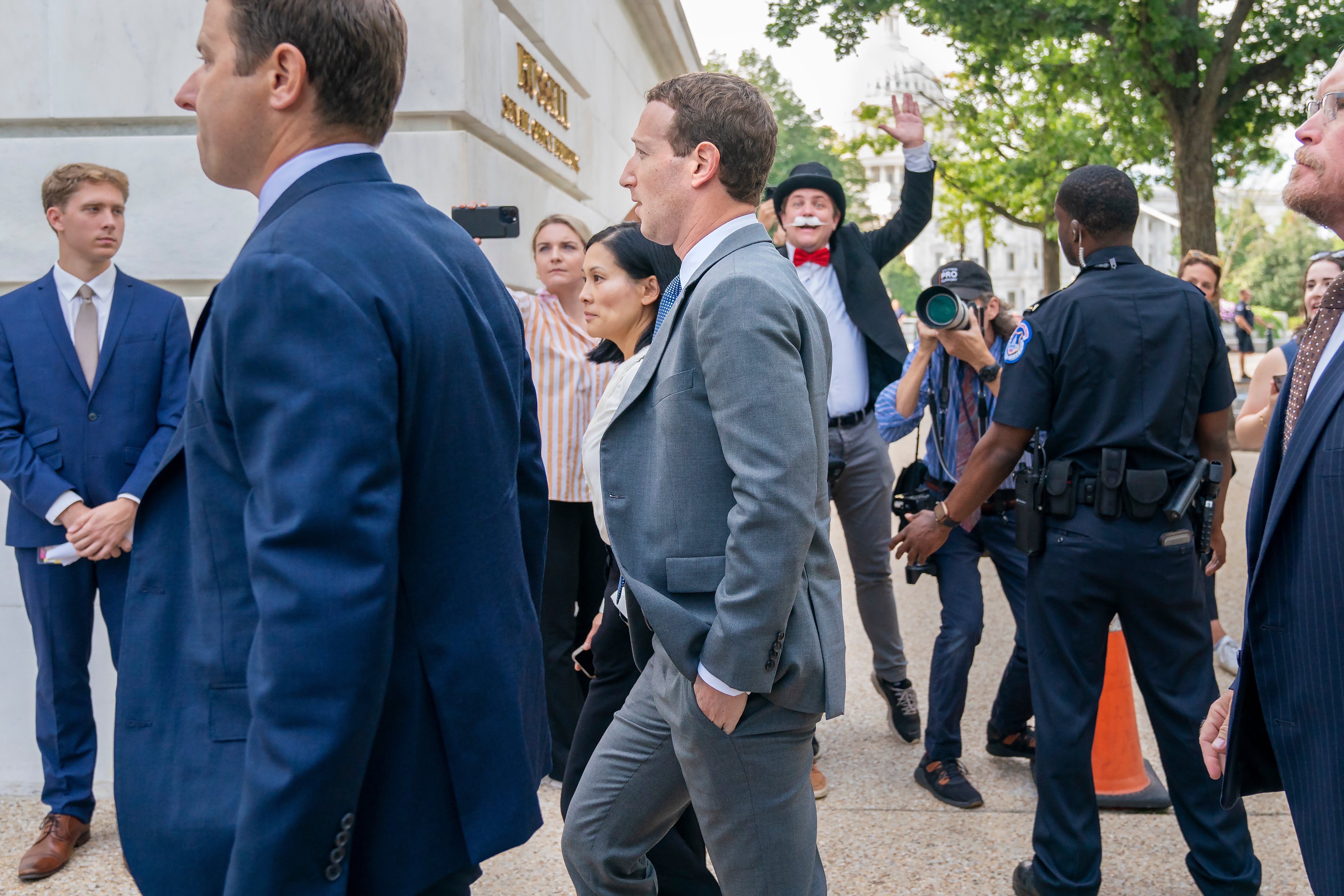 Meta CEO Mark Zuckerberg passes media and a protester as he arrives for a closed-door gathering of leading tech CEOs to discuss the priorities and risks surrounding artificial intelligence, on Capitol Hill in Washington, on Sept. 13, 2023.