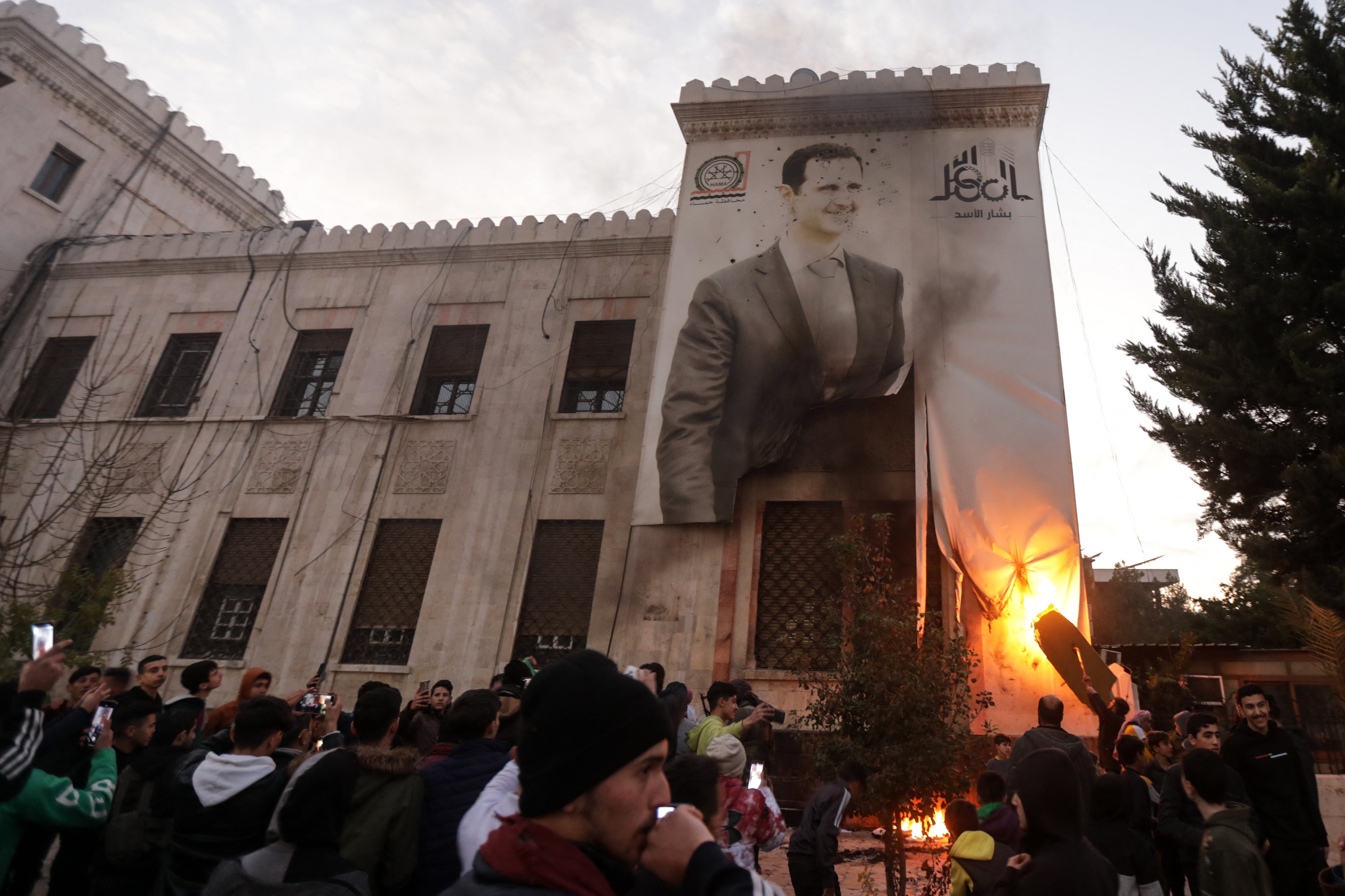 Residents in Hama set ablaze a large banner bearing a picture of Syria’s president Bashar al-Assad