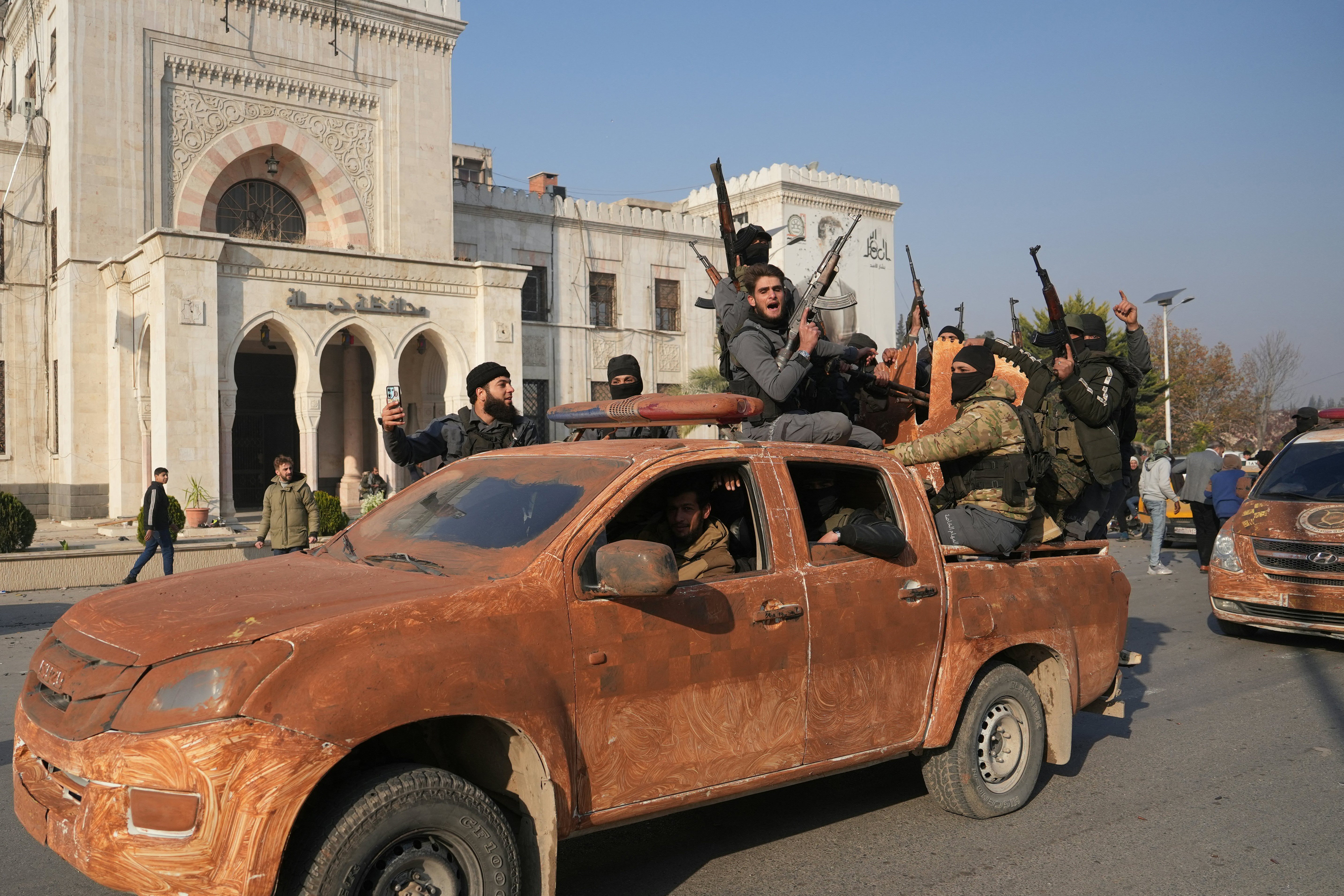 Syrian anti-government fighters celebrate as they pour into the captured city of Hama