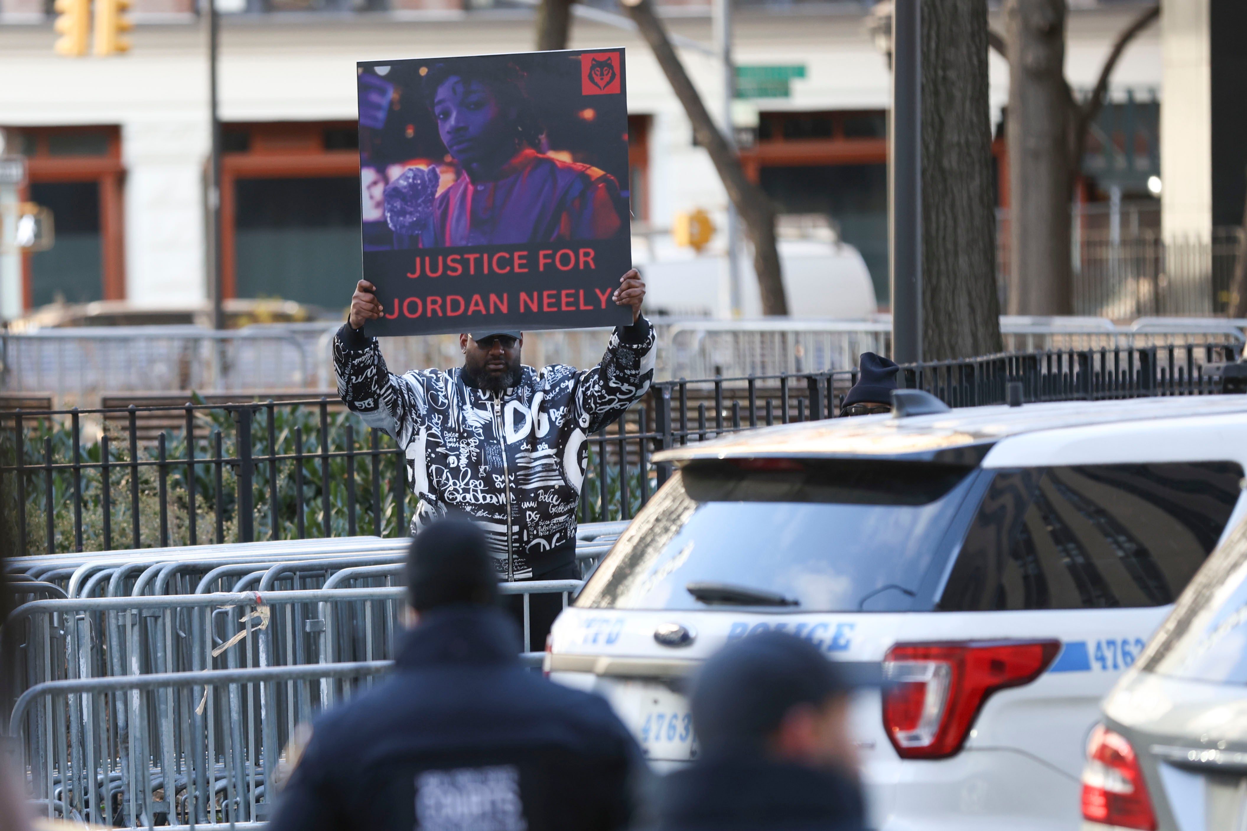 A protestor holds a ‘Justice for Daniel Neely’ sign outside of court