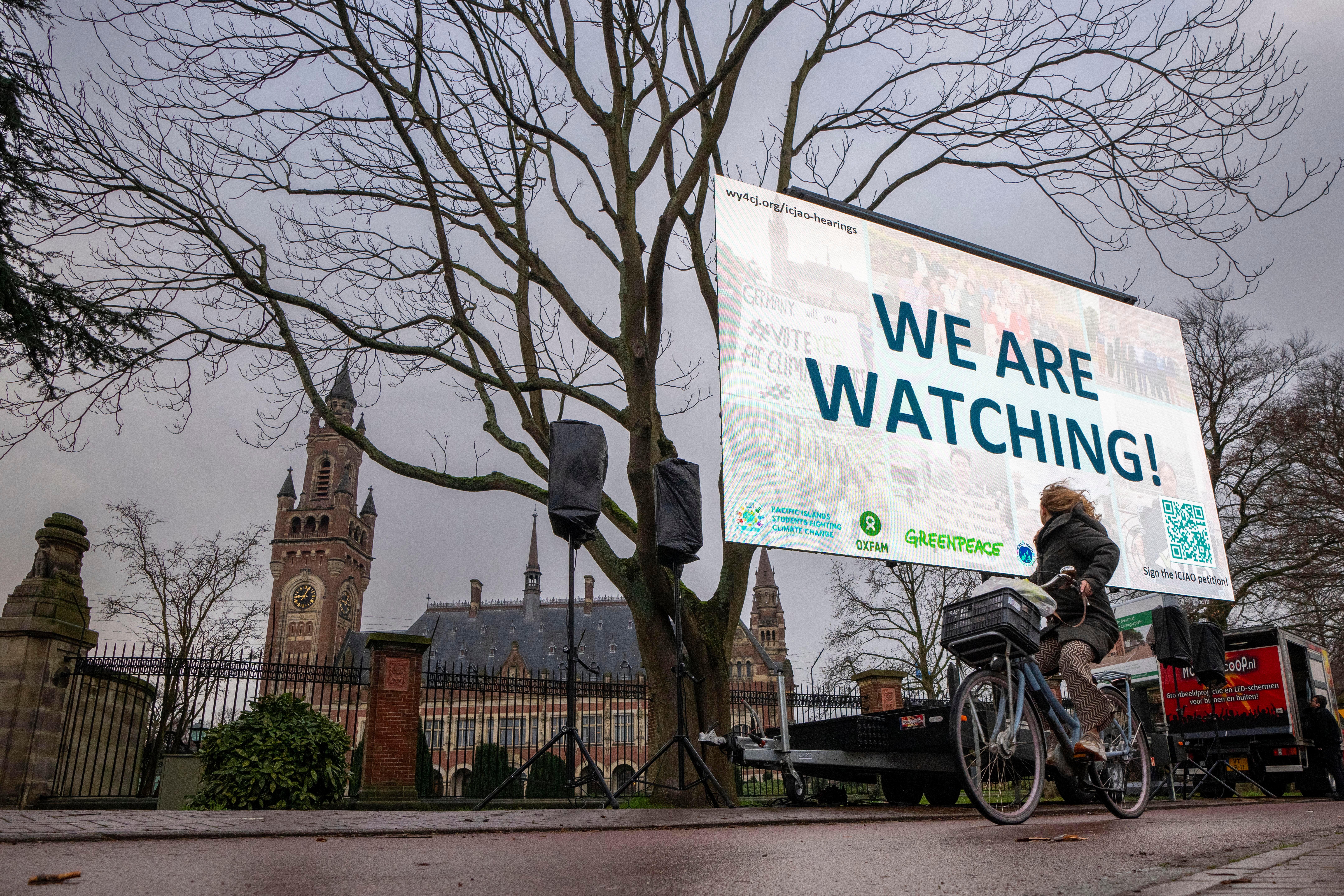 <p>Activists protest outside the International Court of Justice, left, in The Hague </p>