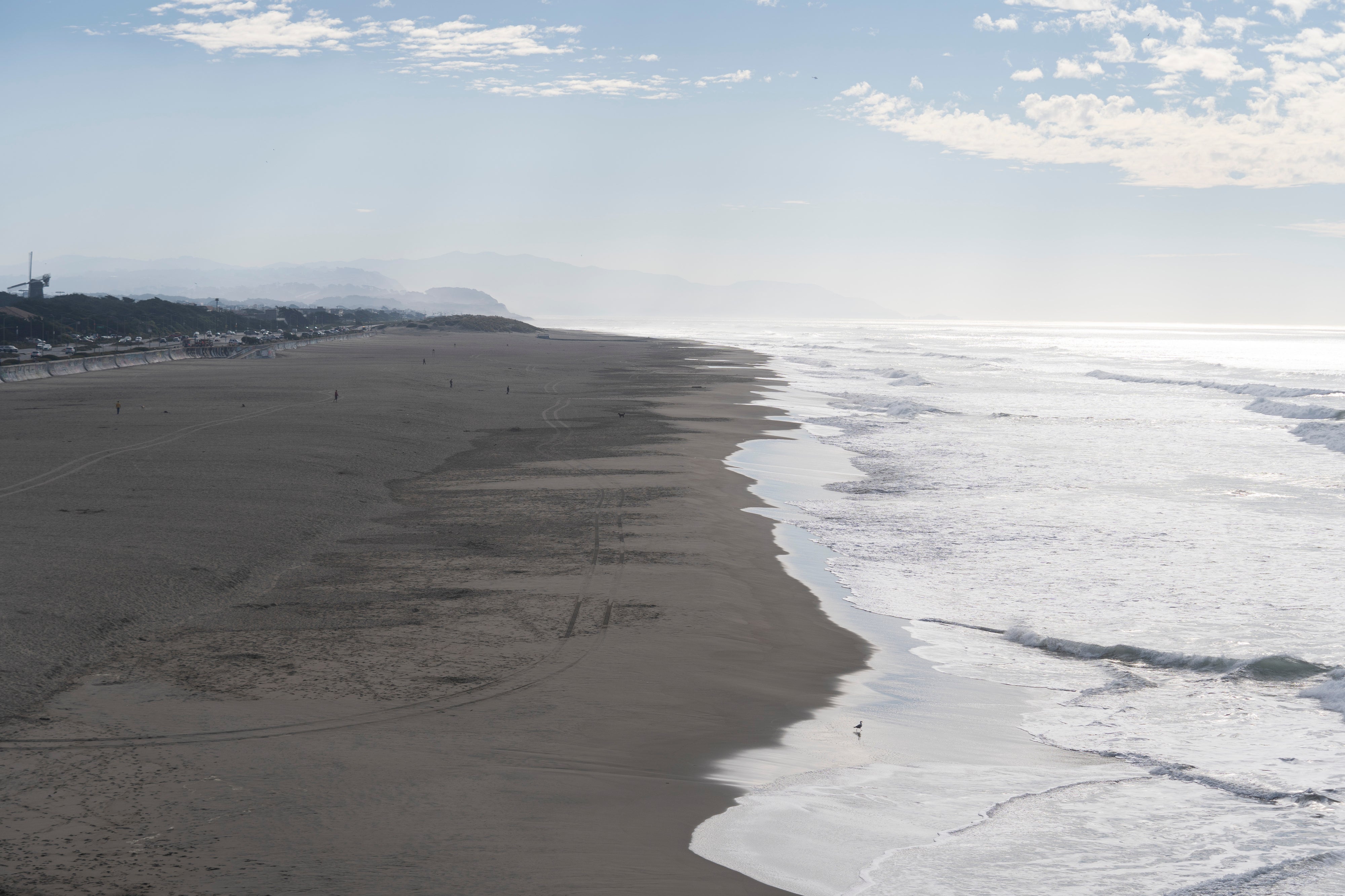 People walk along the sand at Ocean Beach in San Francisco during a tsunami warning on Thursday. During a tsunami, people should head inland and move to higher ground