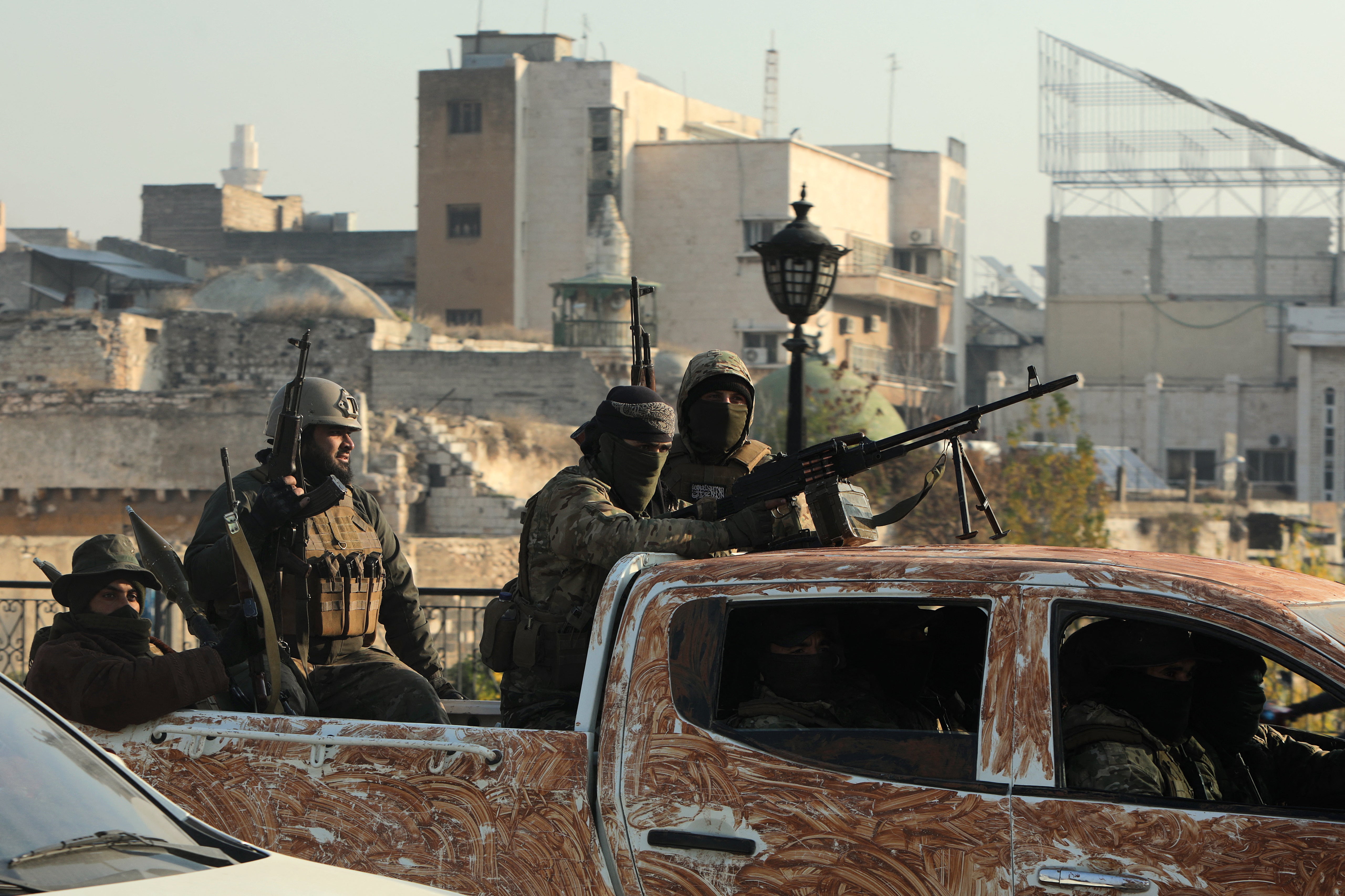 Rebel fighters parade in the streets of Hama after capturing the city in central Syria