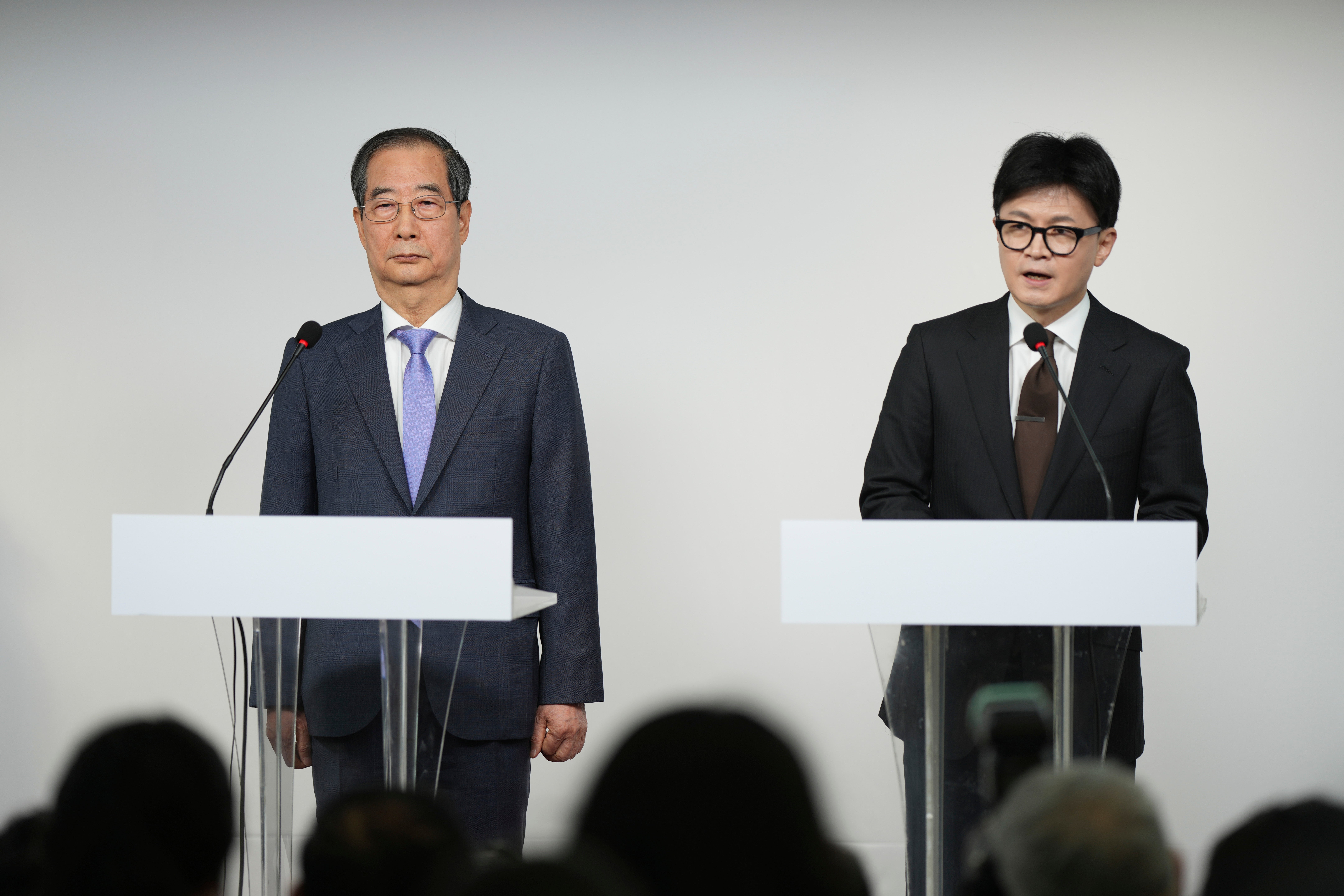 South Korea's ruling People Power Party leader Han Dong-hun, right, speaks as South Korean Prime Minister Han Duck-soo listens during their joint statements in Seoul, South Korea