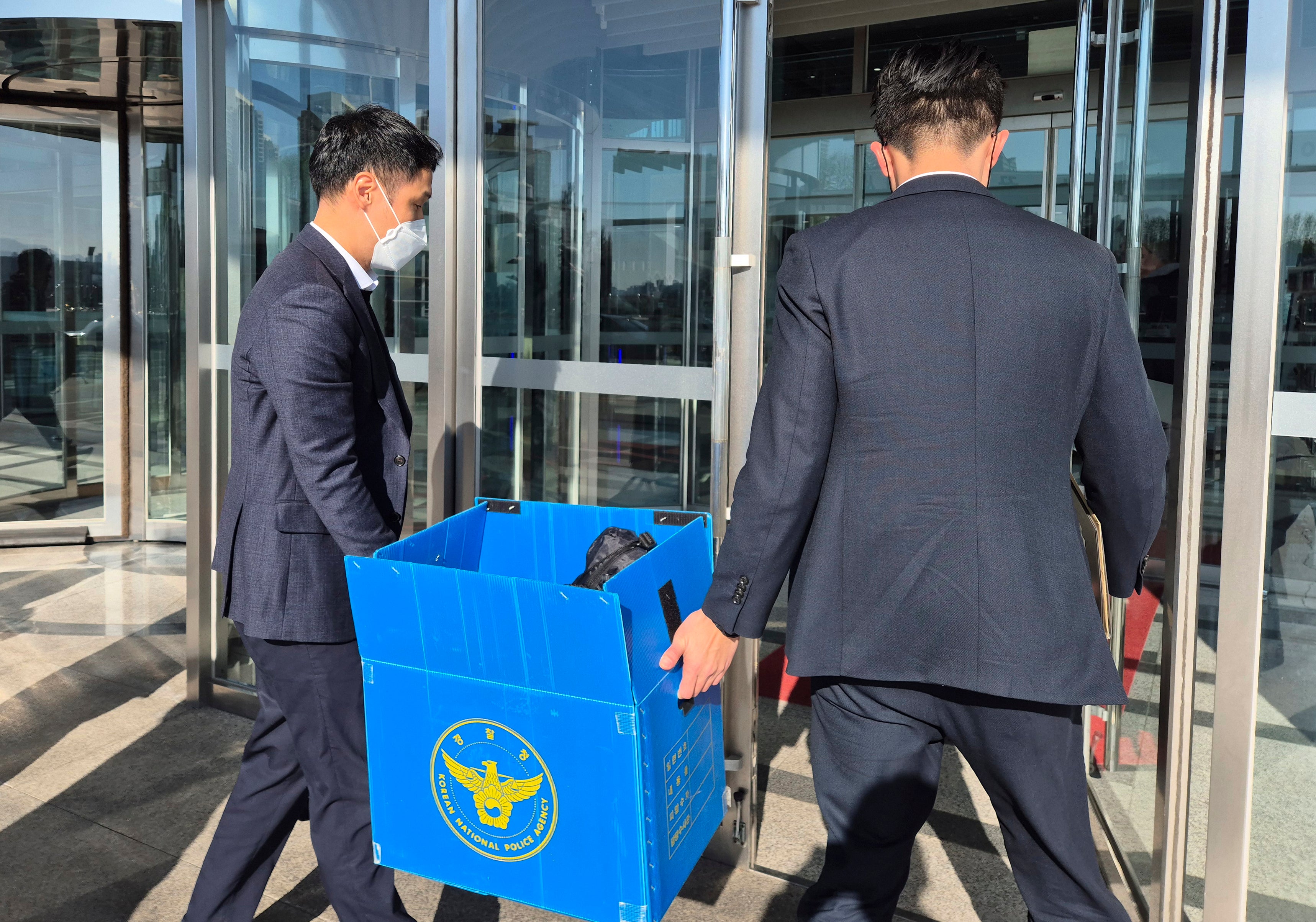 South Korean police officers arrive for the search and seizure at the office of former defence minister Kim Yong Hyun at the Defence Ministry in Seoul