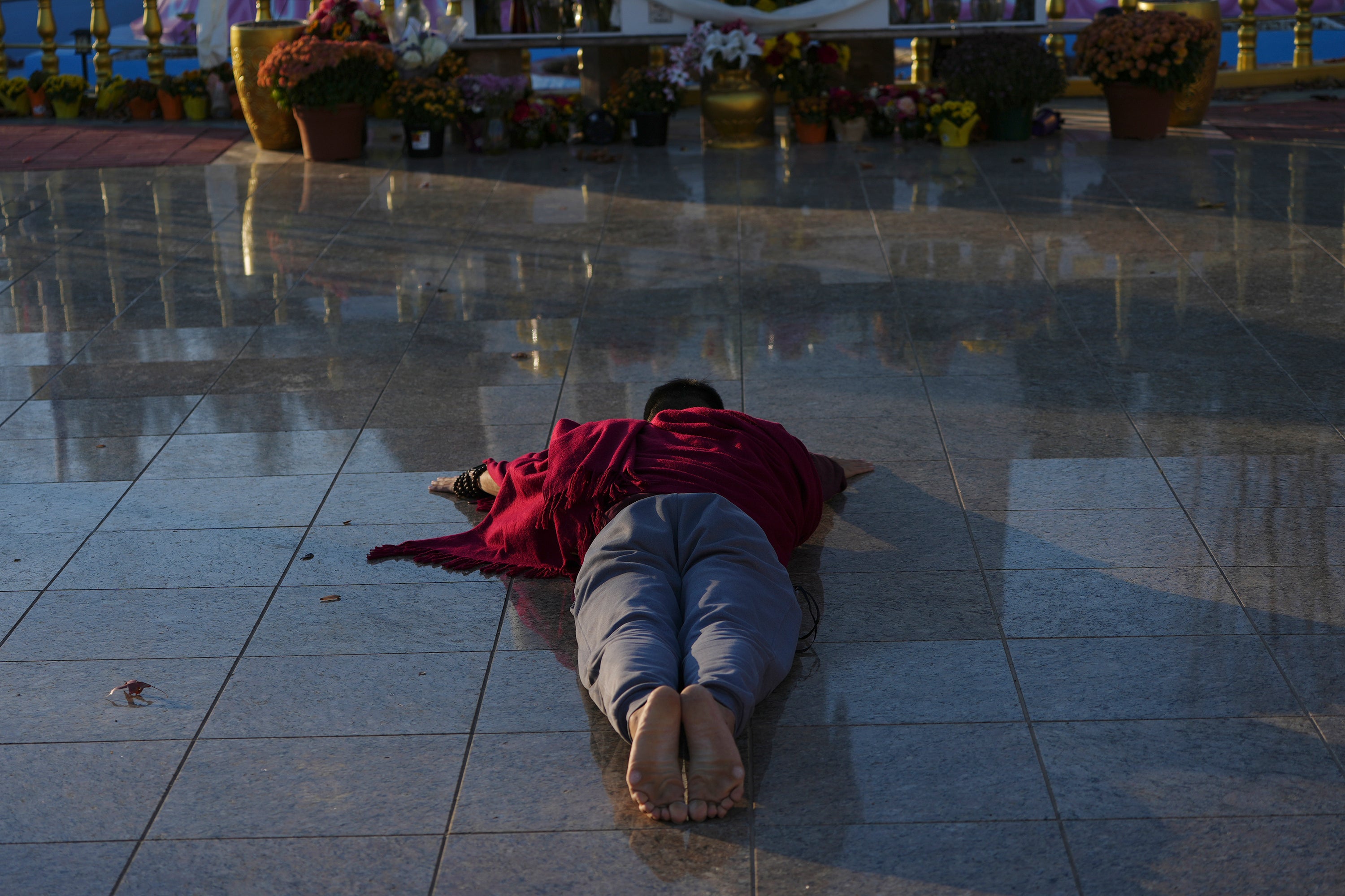 Daniel Choi prostates in front of a giant statue of the Buddha at the New Jersey Buddhist Vihara and Meditation Center