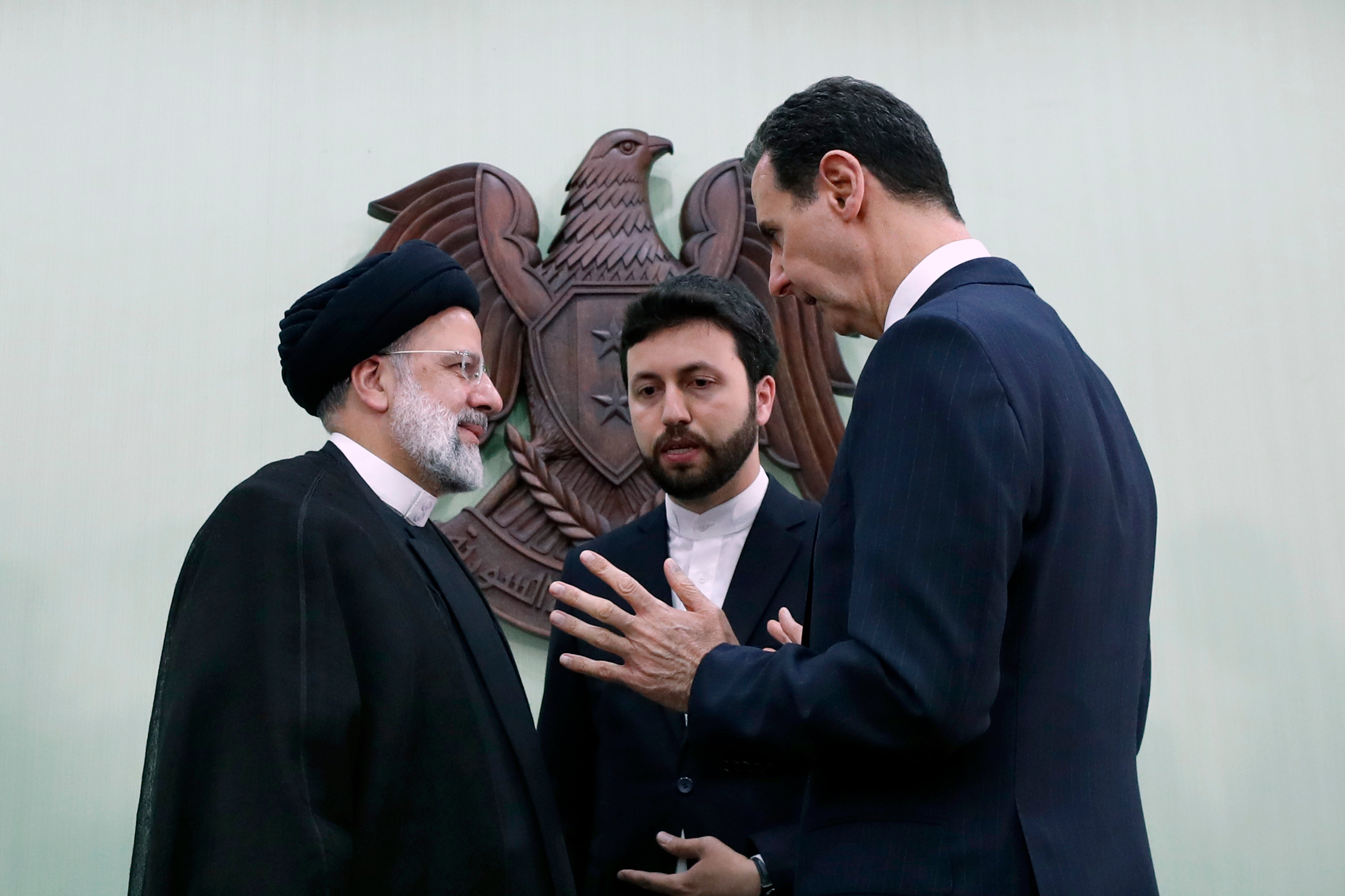 Syrian President Bashar Assad, right, speaks with Iranian President Ebrahim Raisi