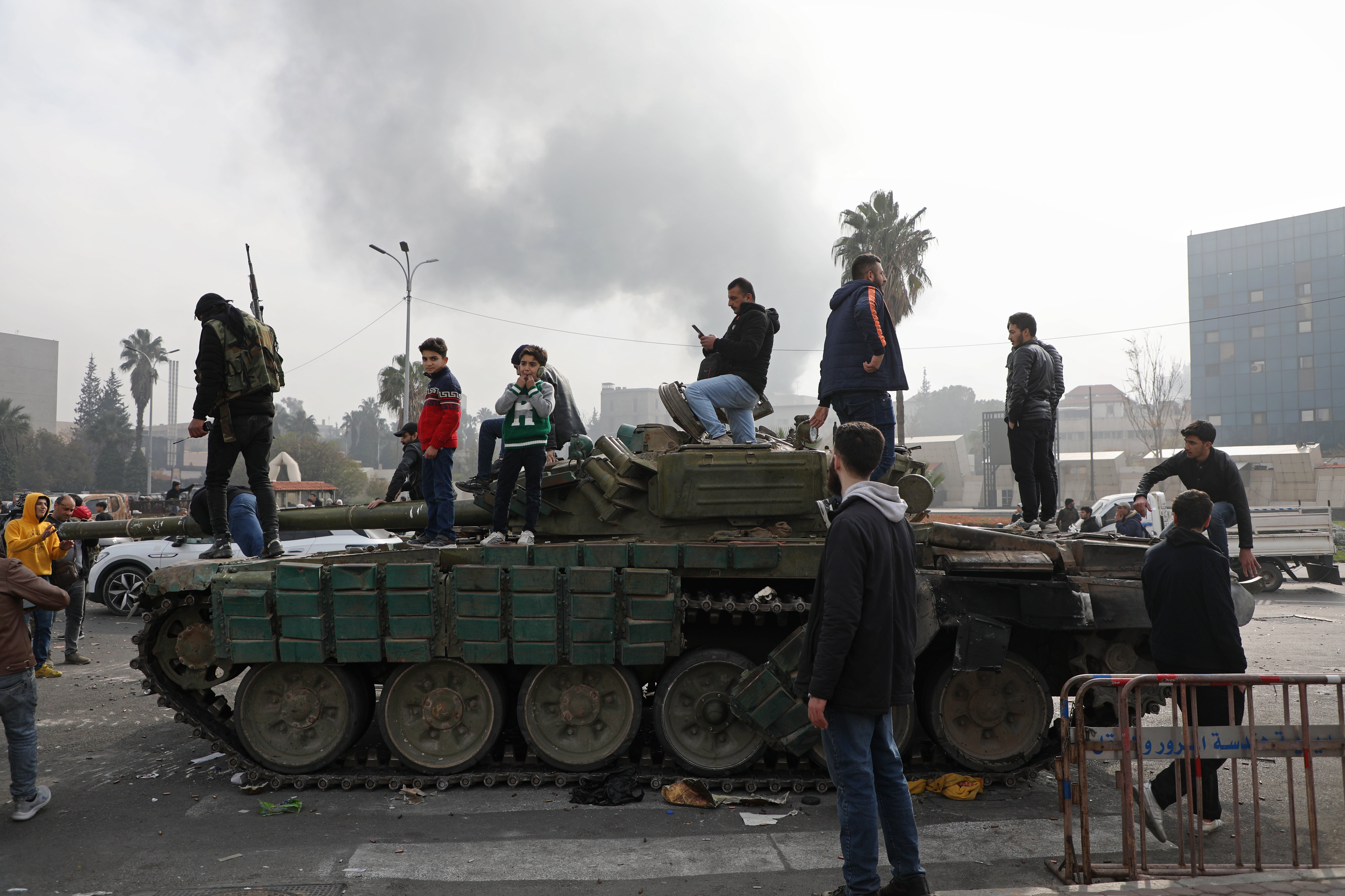 People react to the fall of Syrian regime in Umayyad Square on December 8, 2024 in Damascus