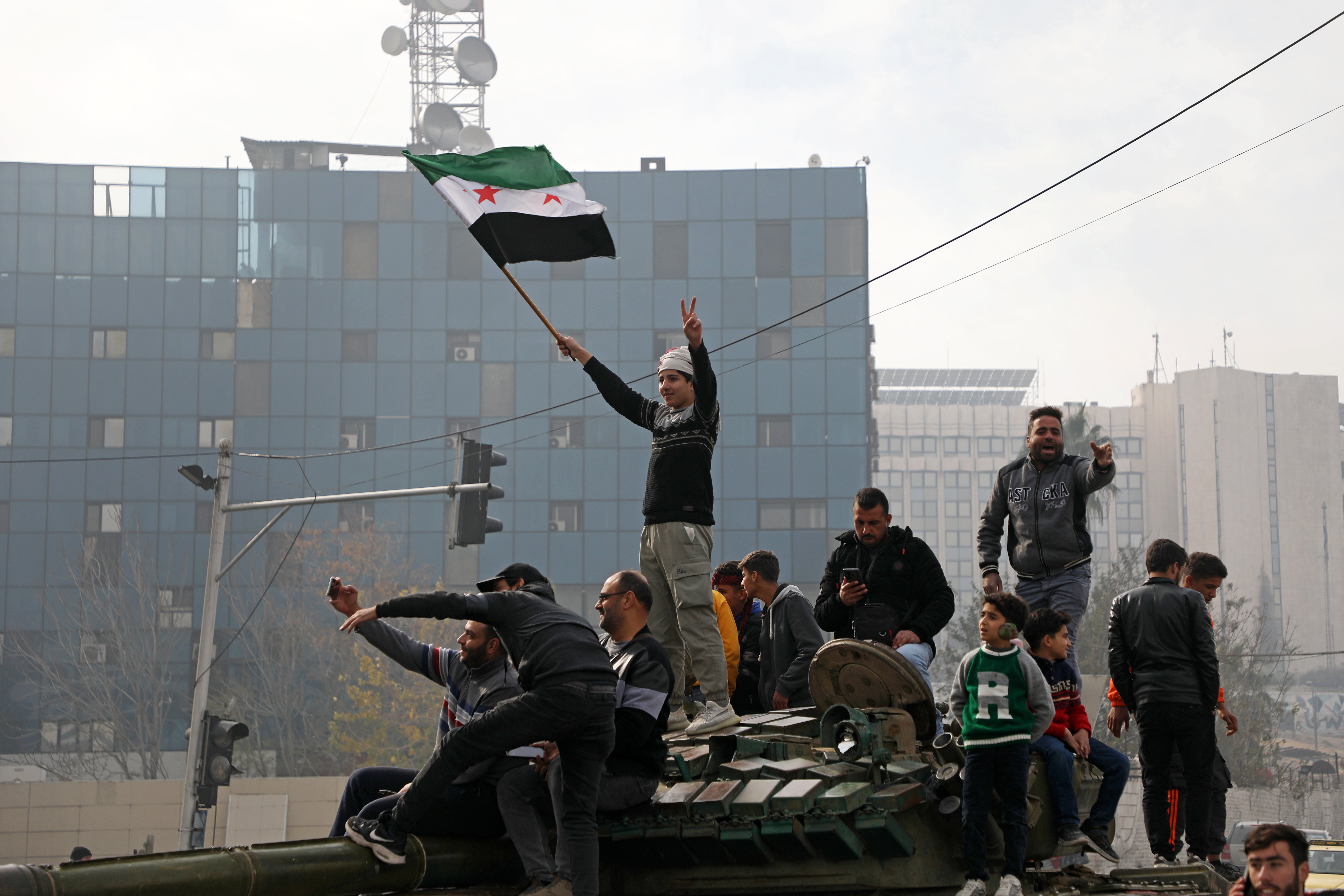 People react to the fall of Syrian regime in Umayyad Square in Damascus