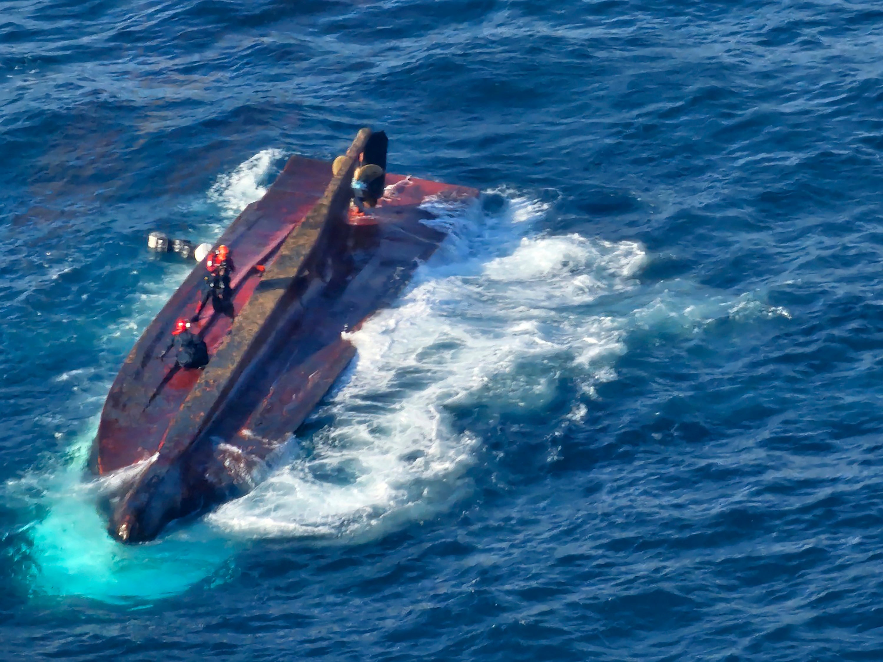 Members of South Korean coast guard conduct a search and rescue operation from a capsized boat in waters off Gyeongju, South Korea