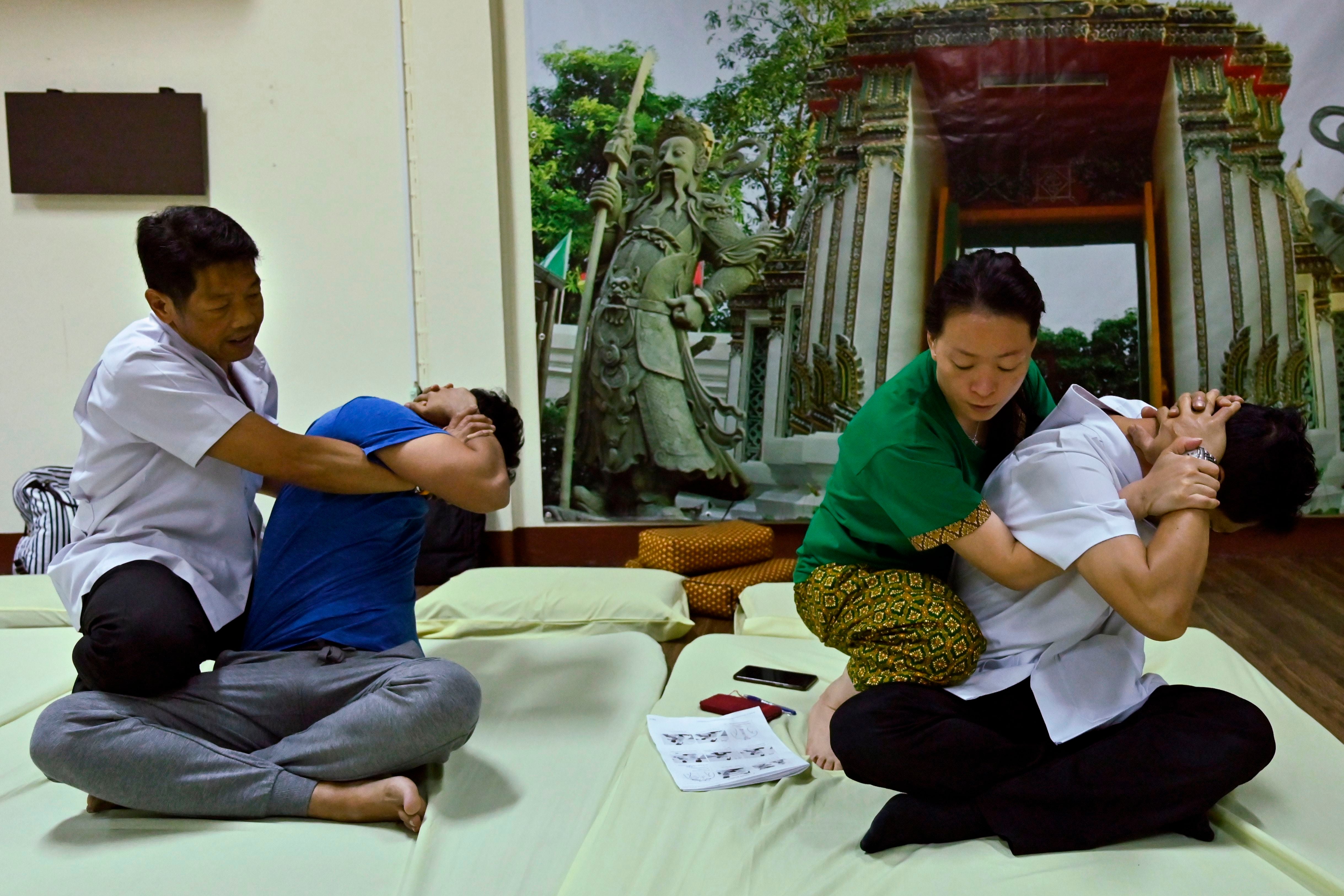 A Thai instructor trains his student from Hong Kong at the Wat Po Thai traditional massage school in Bangkok