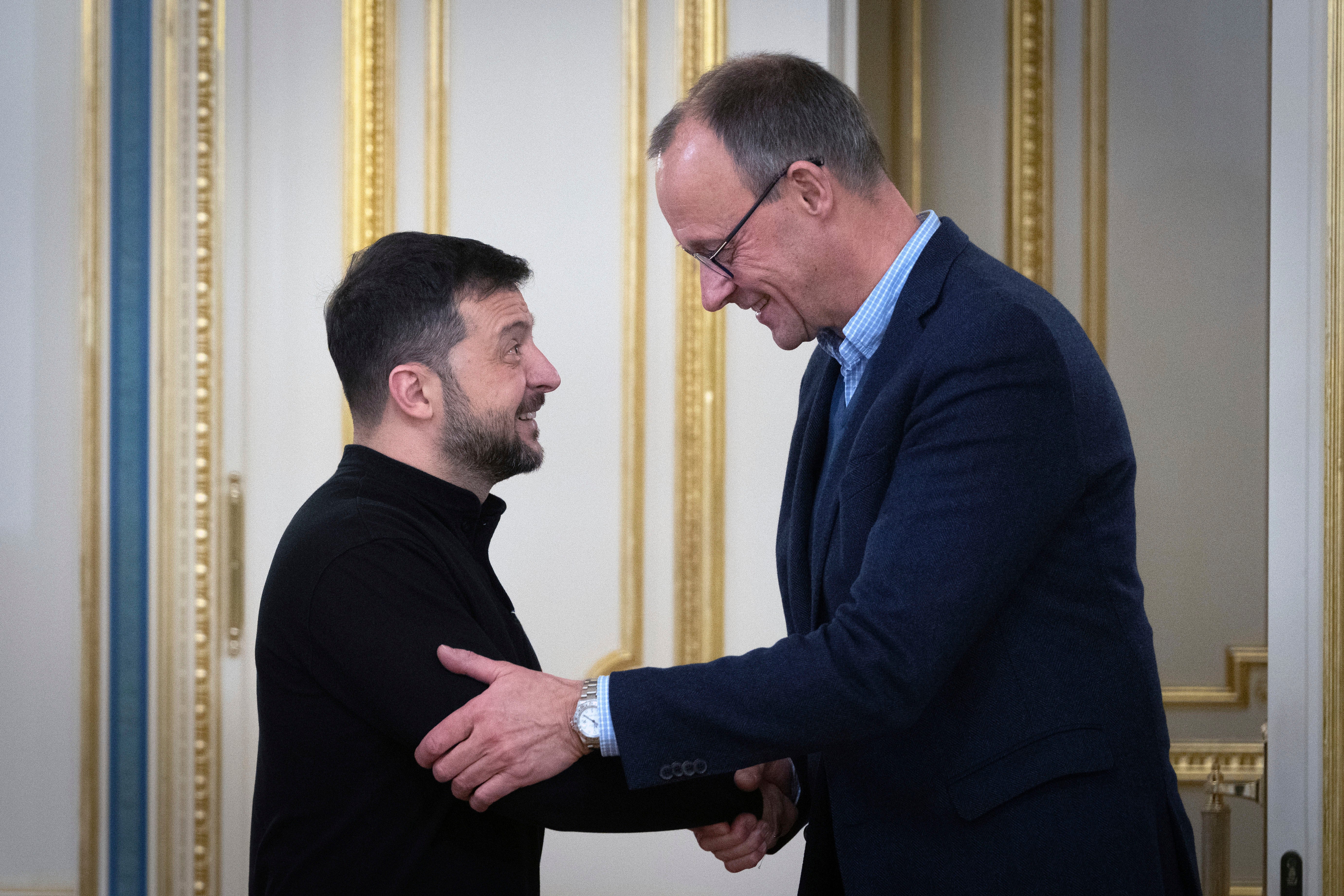 Ukrainian President Volodymyr Zelenskyy, left, and the Chairman of the German Christian Democratic Party (CDU) Friedrich Merz shake hands during their meeting in Kyiv, Ukraine