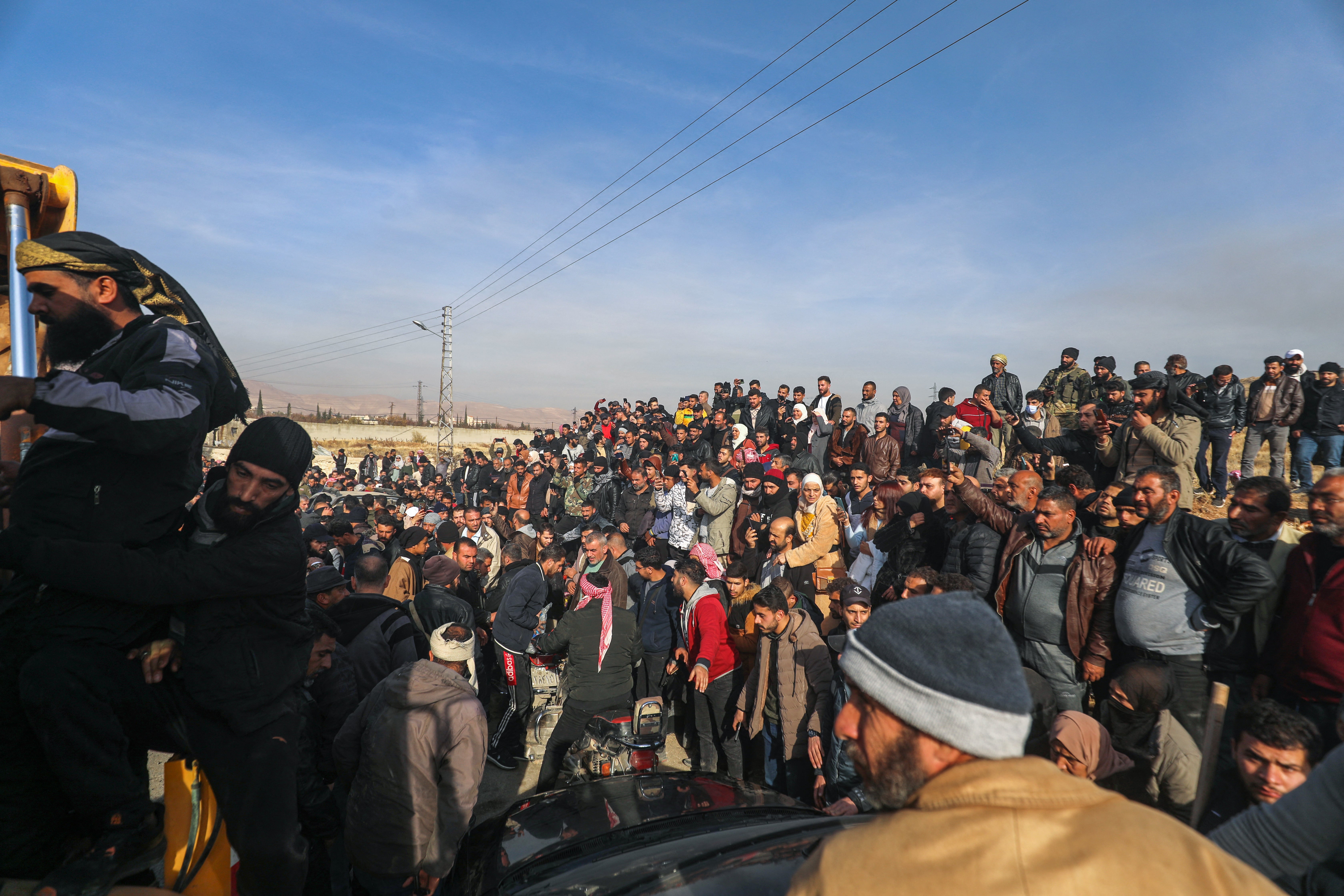 People gather as Syrian White Helmets civil defence members and experts search for potential hidden basements at the Saydnaya prison