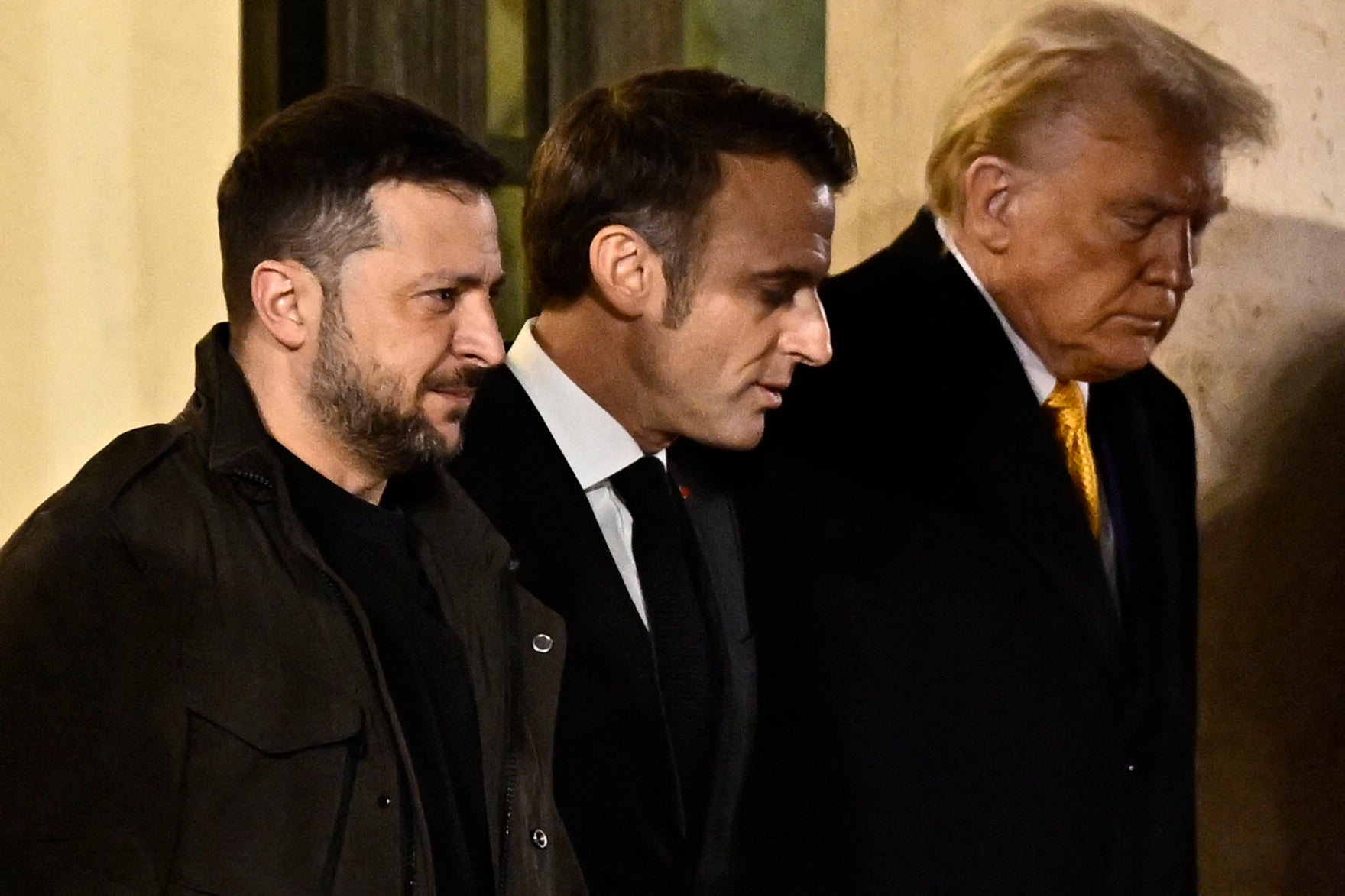 France's President Emmanuel Macron (centre) walks with US president-elect Donald Trump (right) and Ukraine's President Volodymyr Zelensky (left) after a meeting at the Elysee Presidential Palace in Paris on 7 December