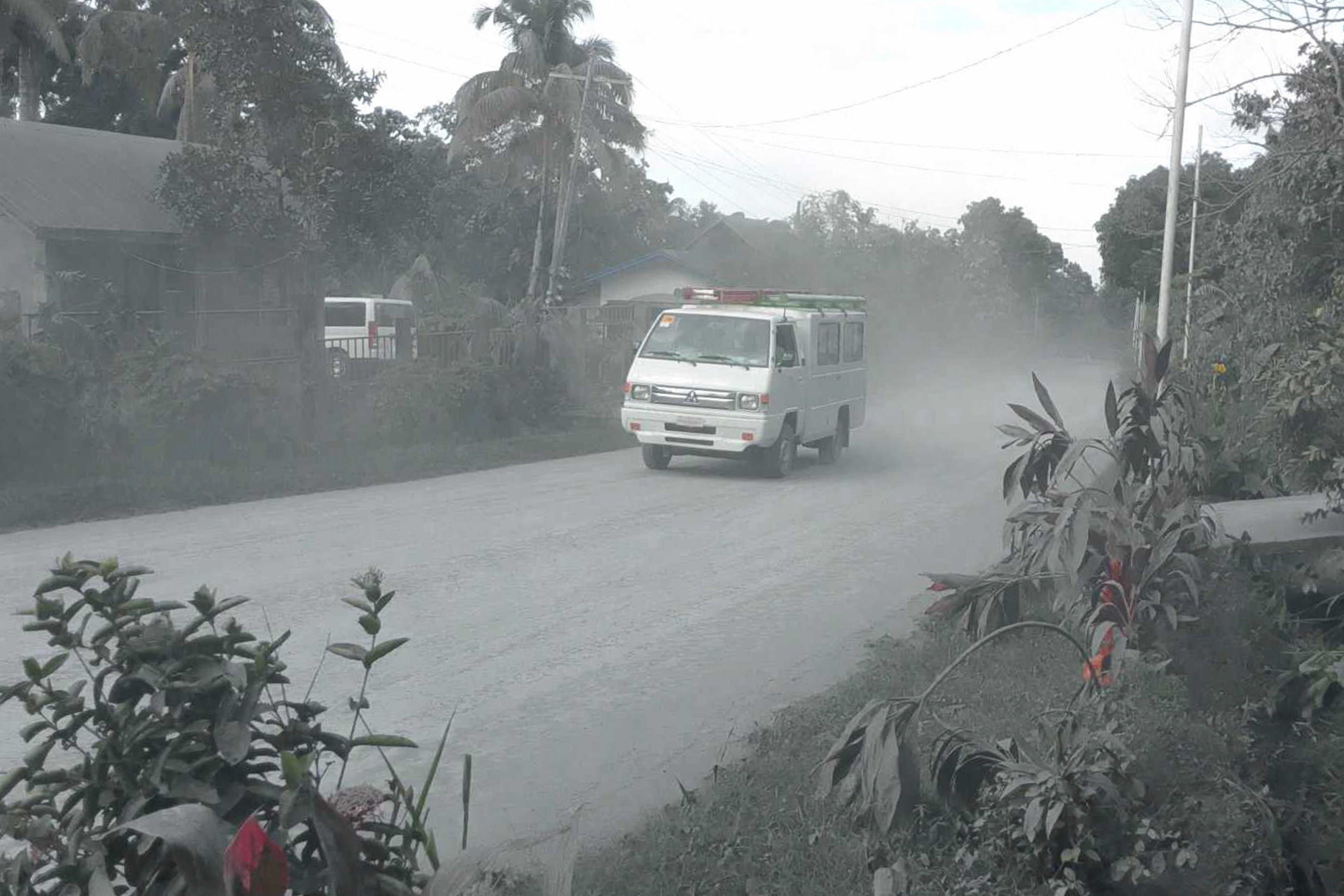 A vehicle negotiates a road covered with volcanic ash at Bago city in the Negros Occidental province of the Philippines