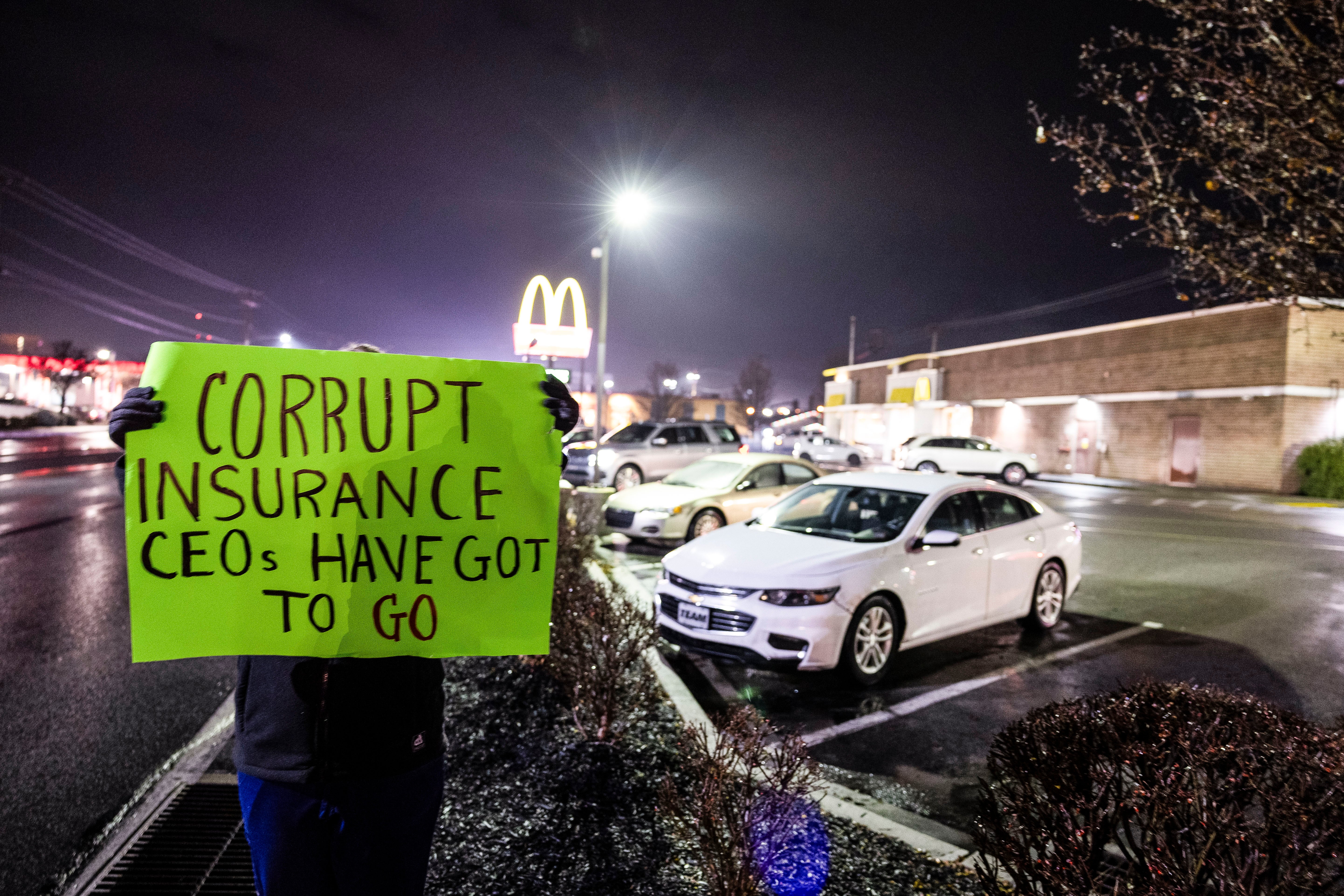 A woman, who did not want to be identified and who works in the healthcare industry, holds a protest sign outside the McDonald’s restaurant where Altoona Police arrested Luigi Mangione, who is a suspect in the fatal shooting of UnitedHealthcare CEO Brian Thompson.