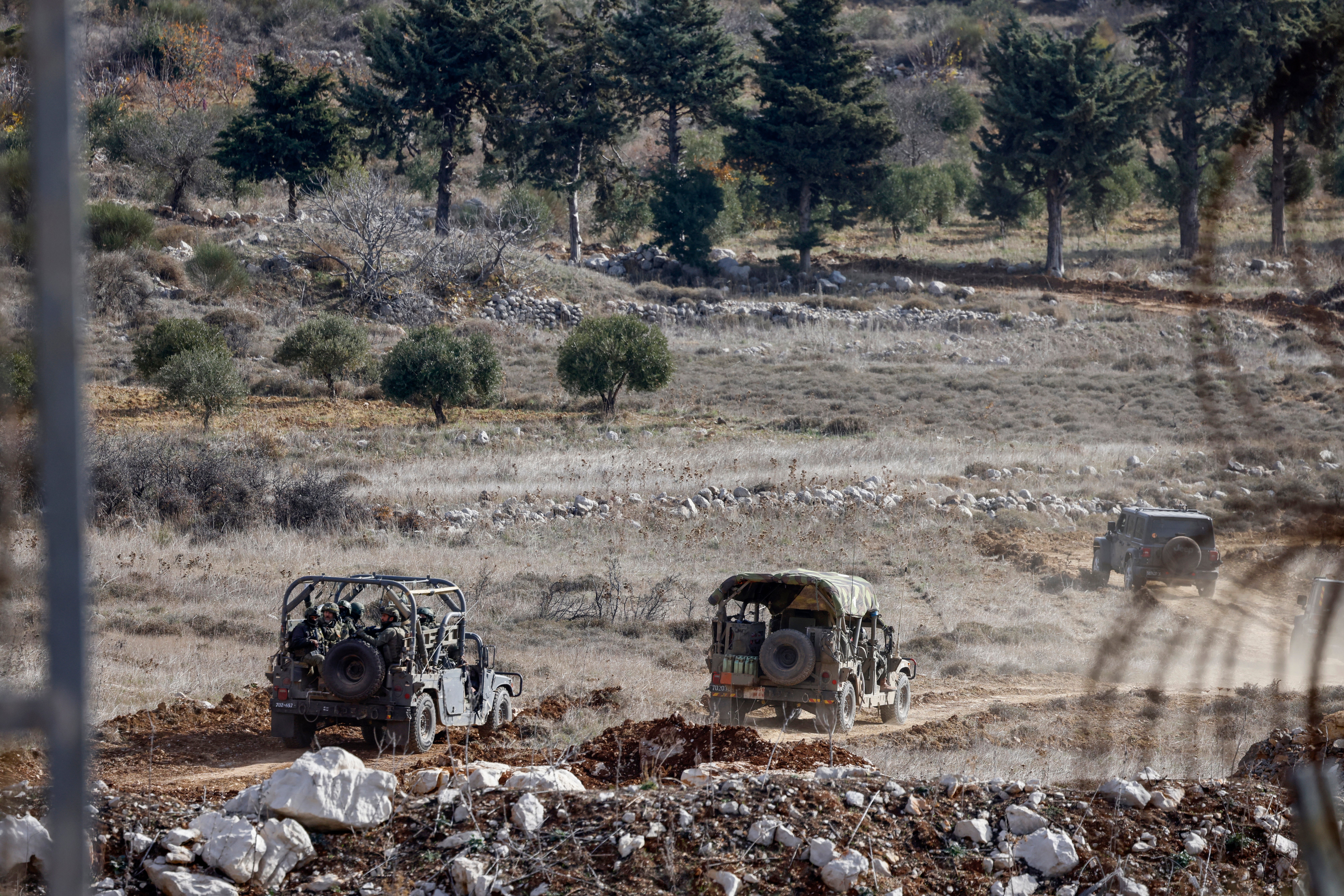 Israeli military vehicles drive after crossing the fence to the buffer zone with Syria, near the Druze village of Majdal Shams in the Israel-annexed Golan Heights