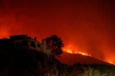 A three-alarm brushfire burns in Malibu, prompting mandatory evacuations