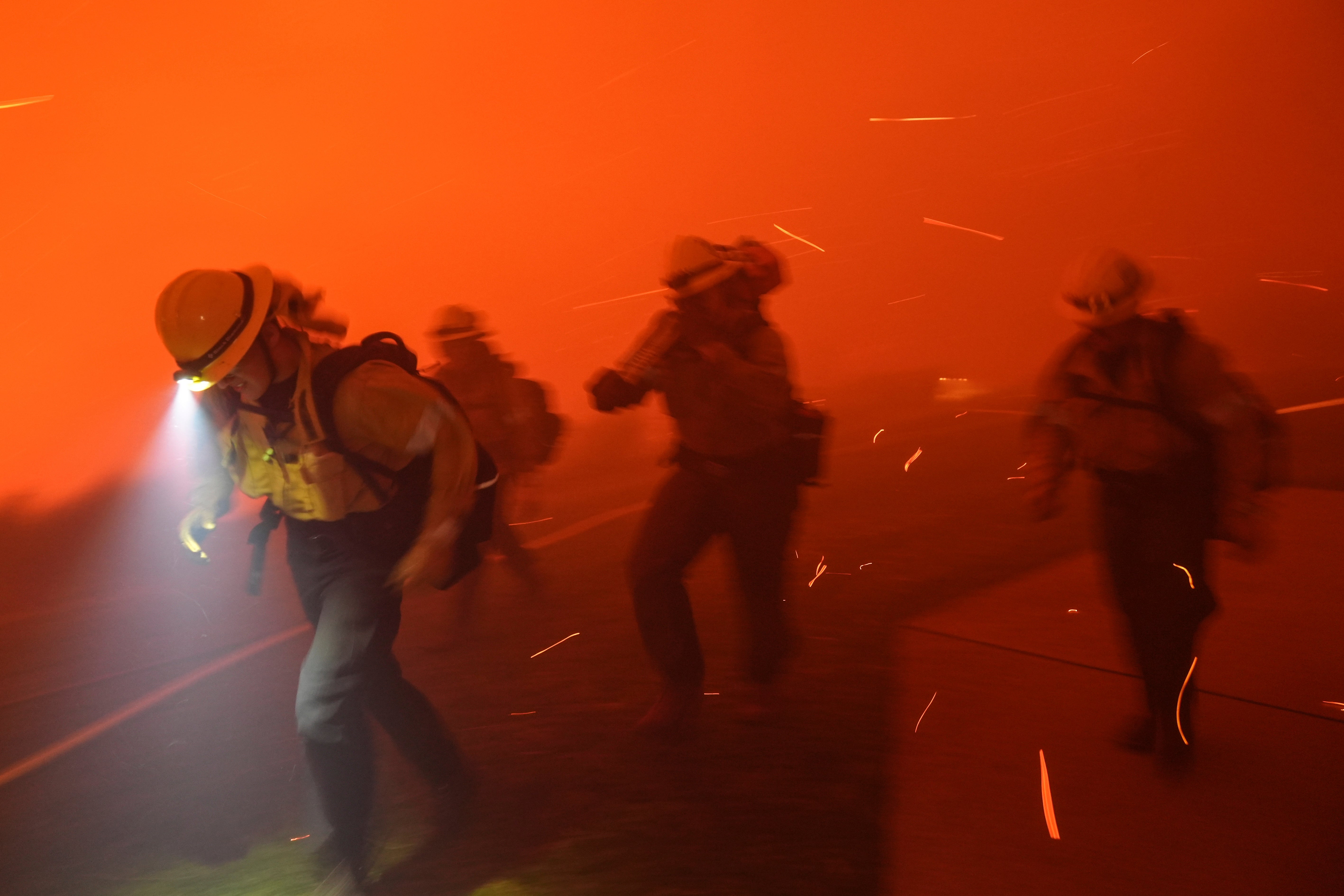 Firefighters are pushed back on Tuesday by the gusty Santa Ana winds near Malibu’s Pepperdine University. The firefighters were moving fuel from the area as the Franklin Fire approached