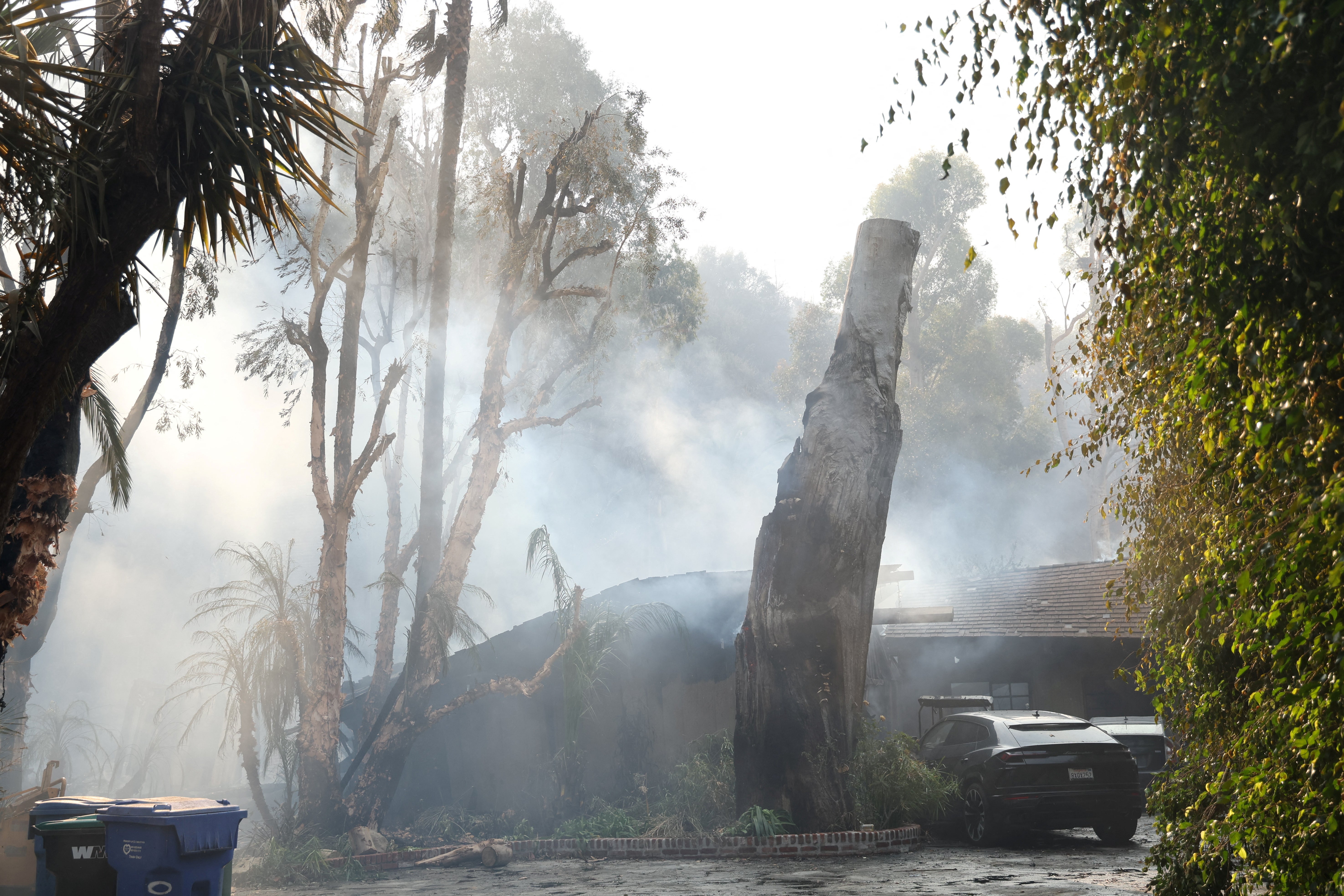 Smoke billows from a partially burnt house on Tuesday in Malibu, California. The fire was continuing to spread on Tuesday