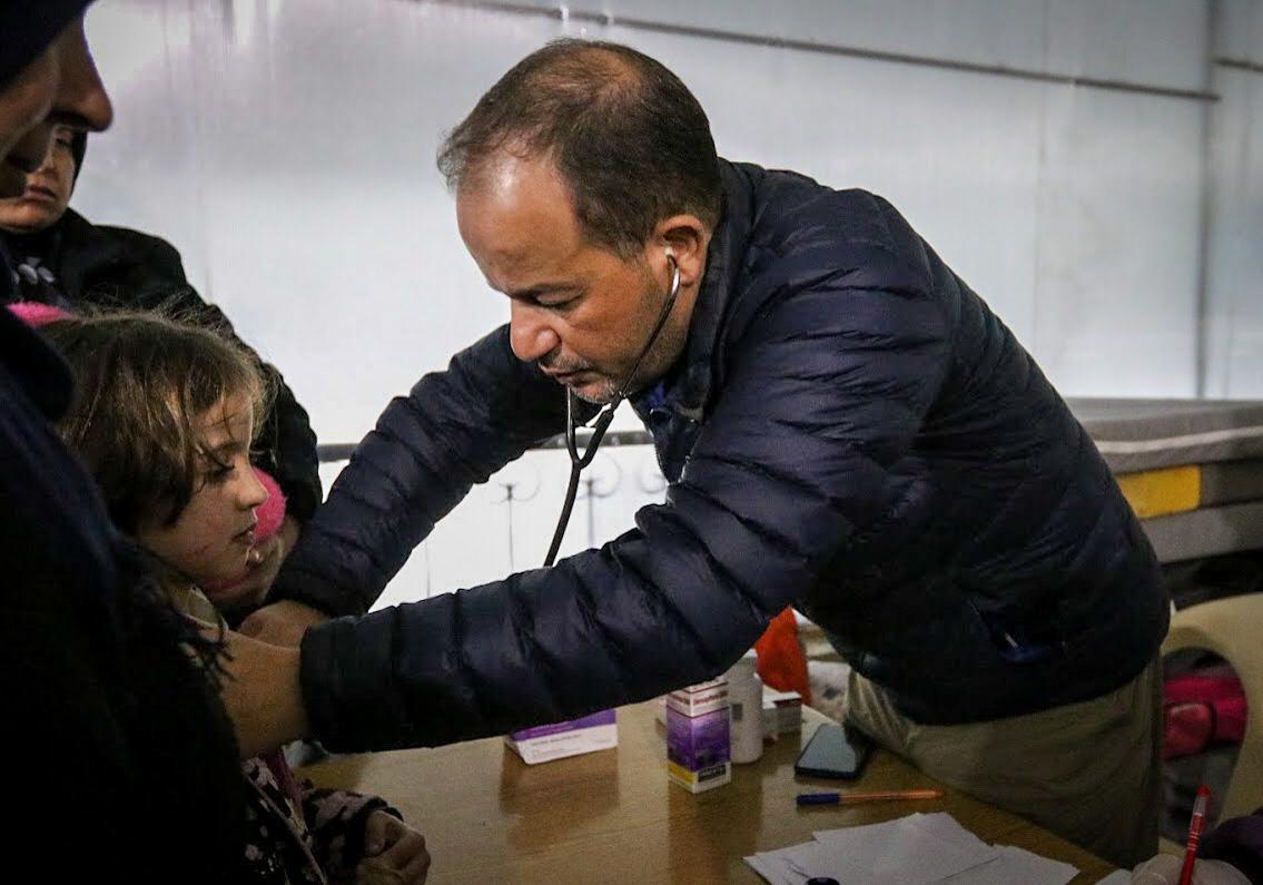 Dr Zaher Sahloul helping a patient in Idlib in 2020.