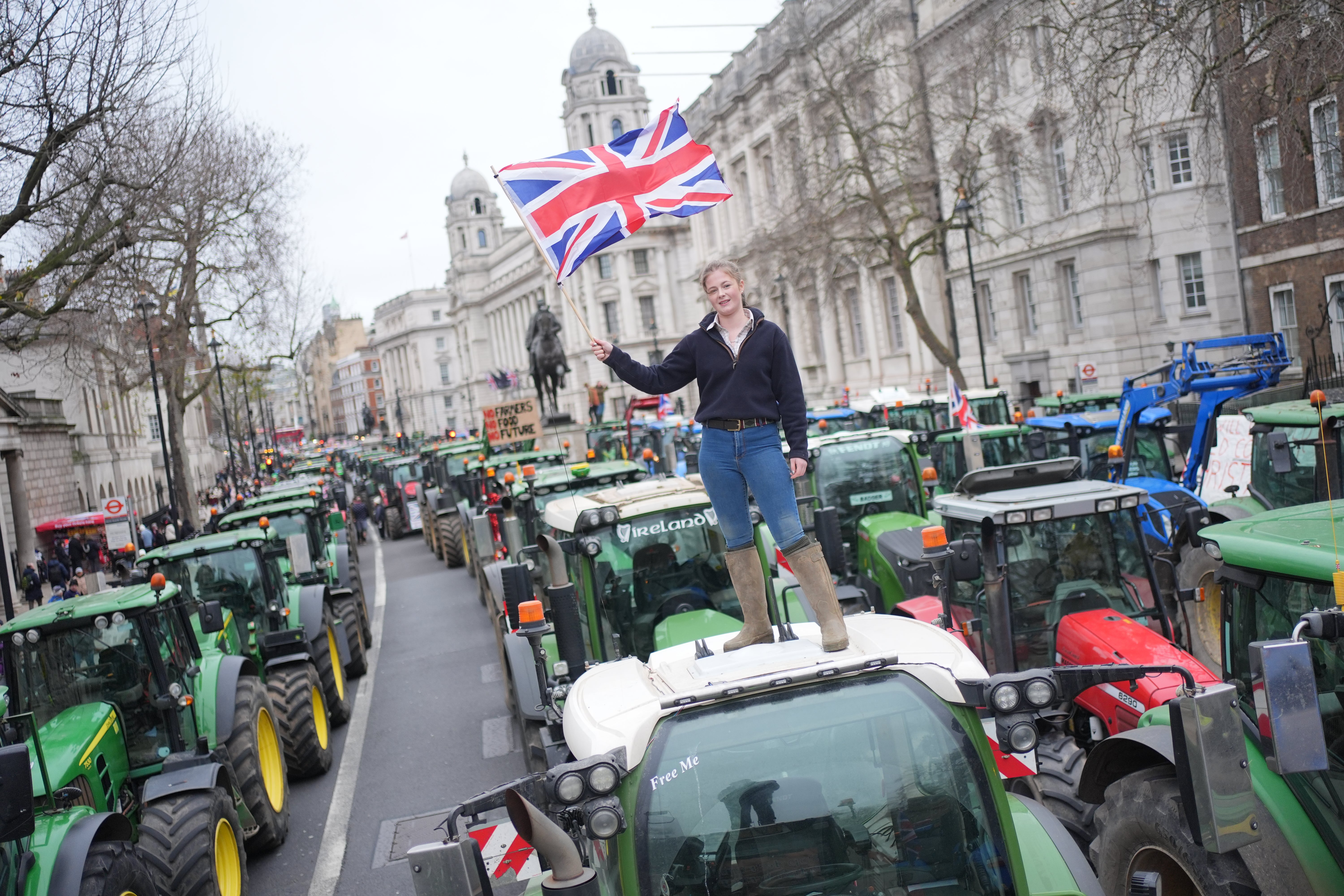 Farmer's daughter Millie Goodwin, 18, stands on a tractor lined up in Whitehall ahead of the procession around Westminster