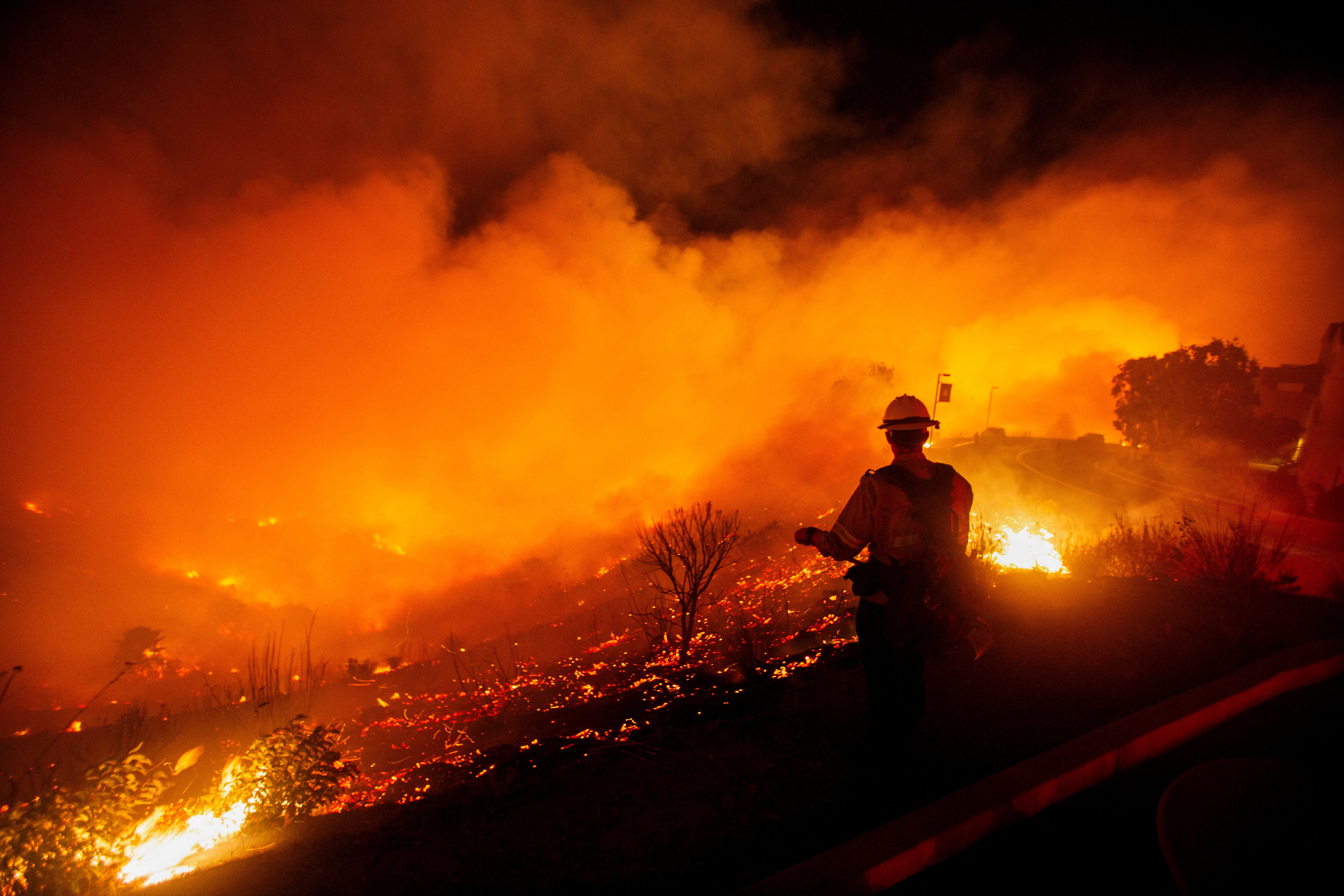 A firefighter watches as the Franklin Fire burns on Tuesday in Malibu, California