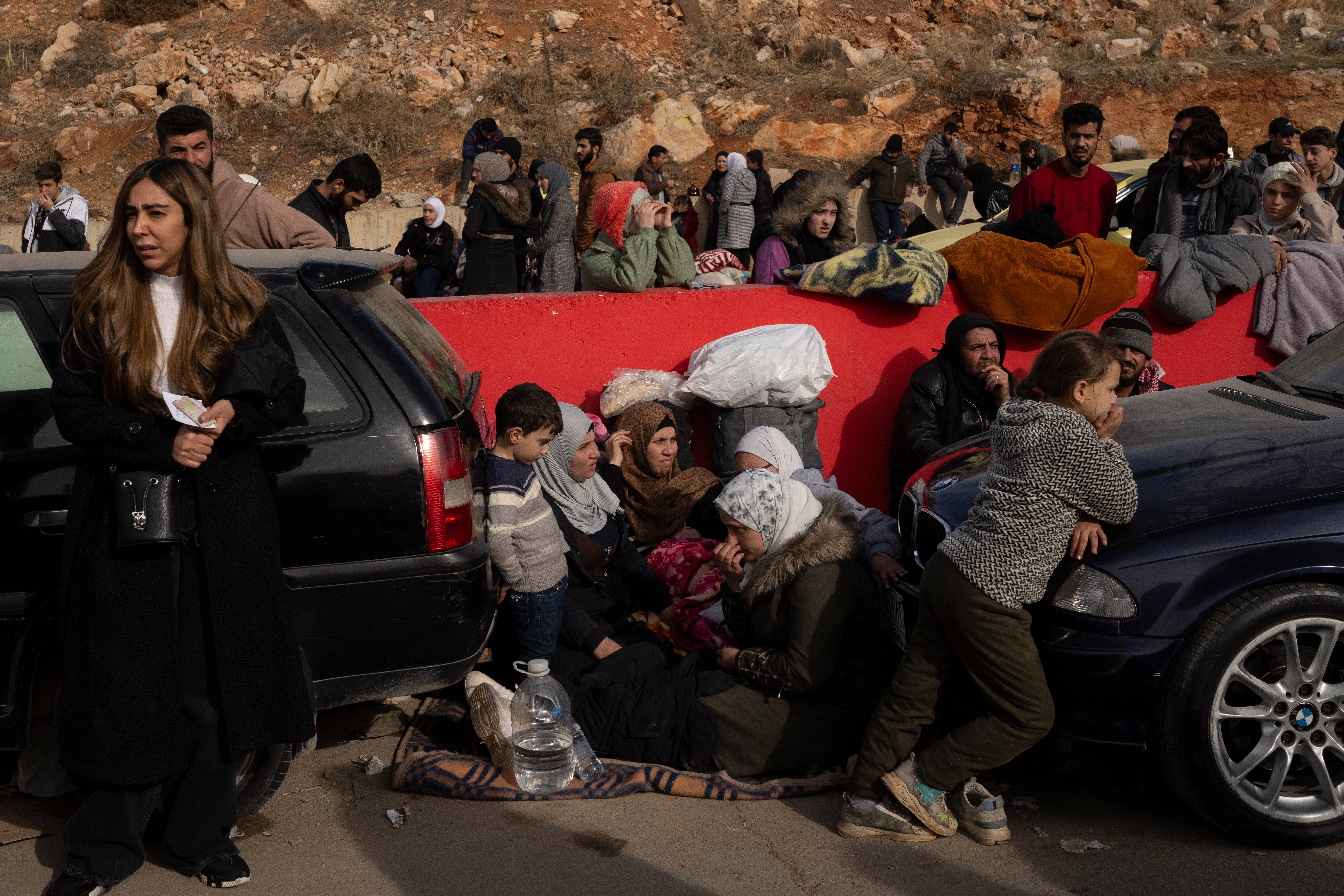 Syrians wait on the road to cross into Lebanon near the Masnaa crossing border, as seen from east Lebanon