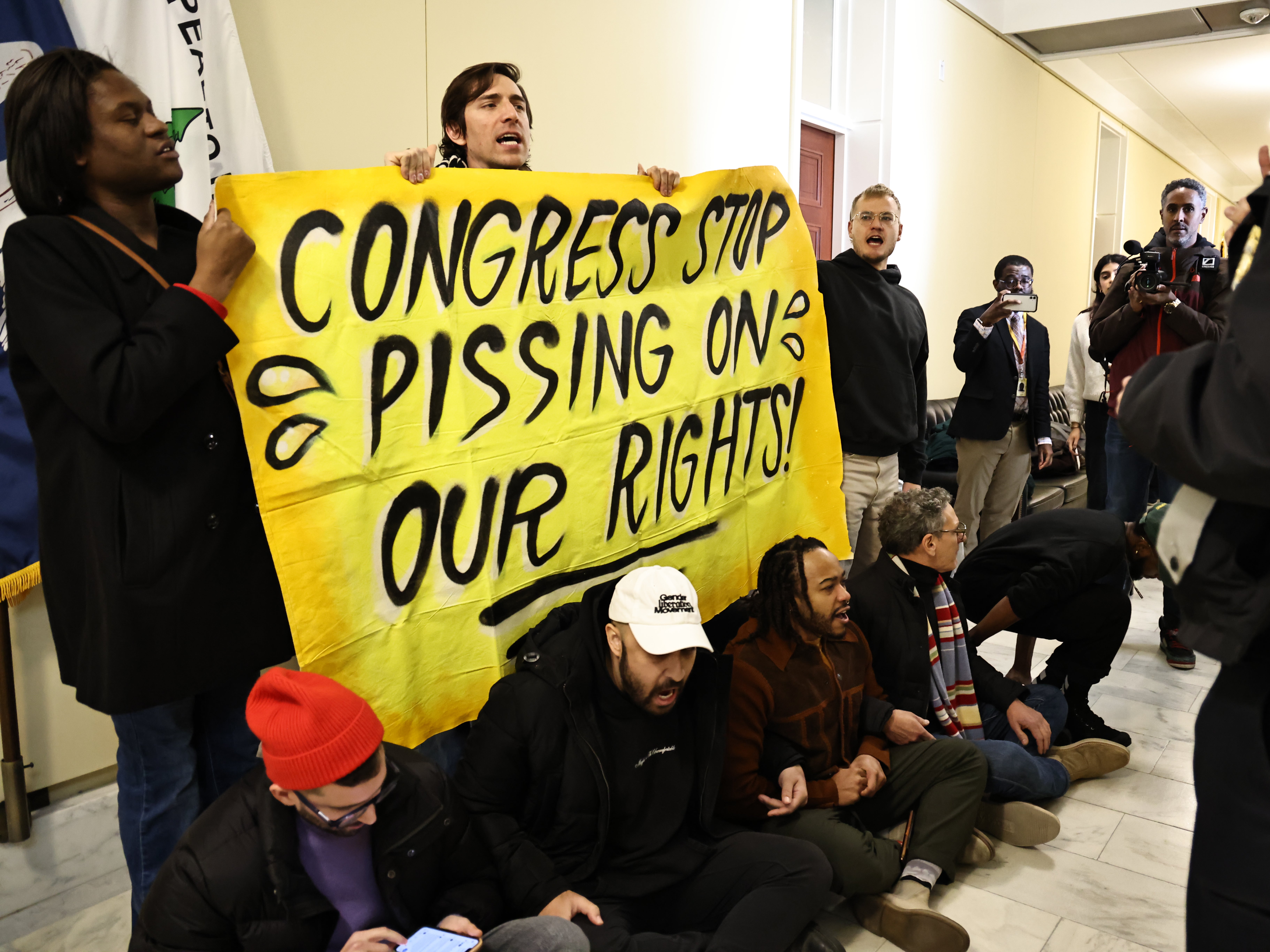 Trans rights protesters make noise outside a women’s bathroom in the US Capitol on Thursday Dec 5, 2024