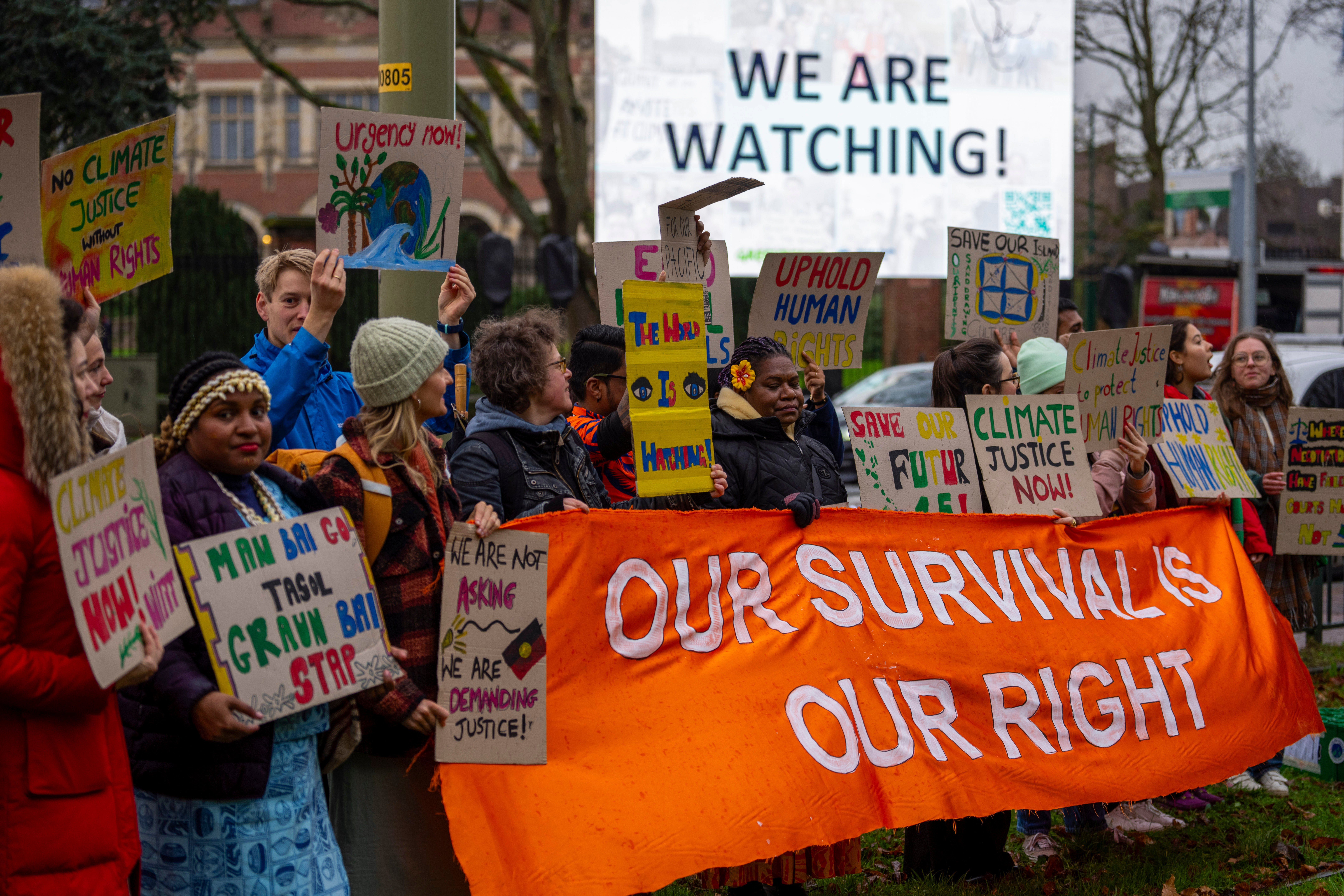 Activists protest outside the International Court of Justice, in The Hague, Netherlands, as it opens hearings into what countries worldwide are legally required to do to combat climate change and help vulnerable nations fight its devastating impact
