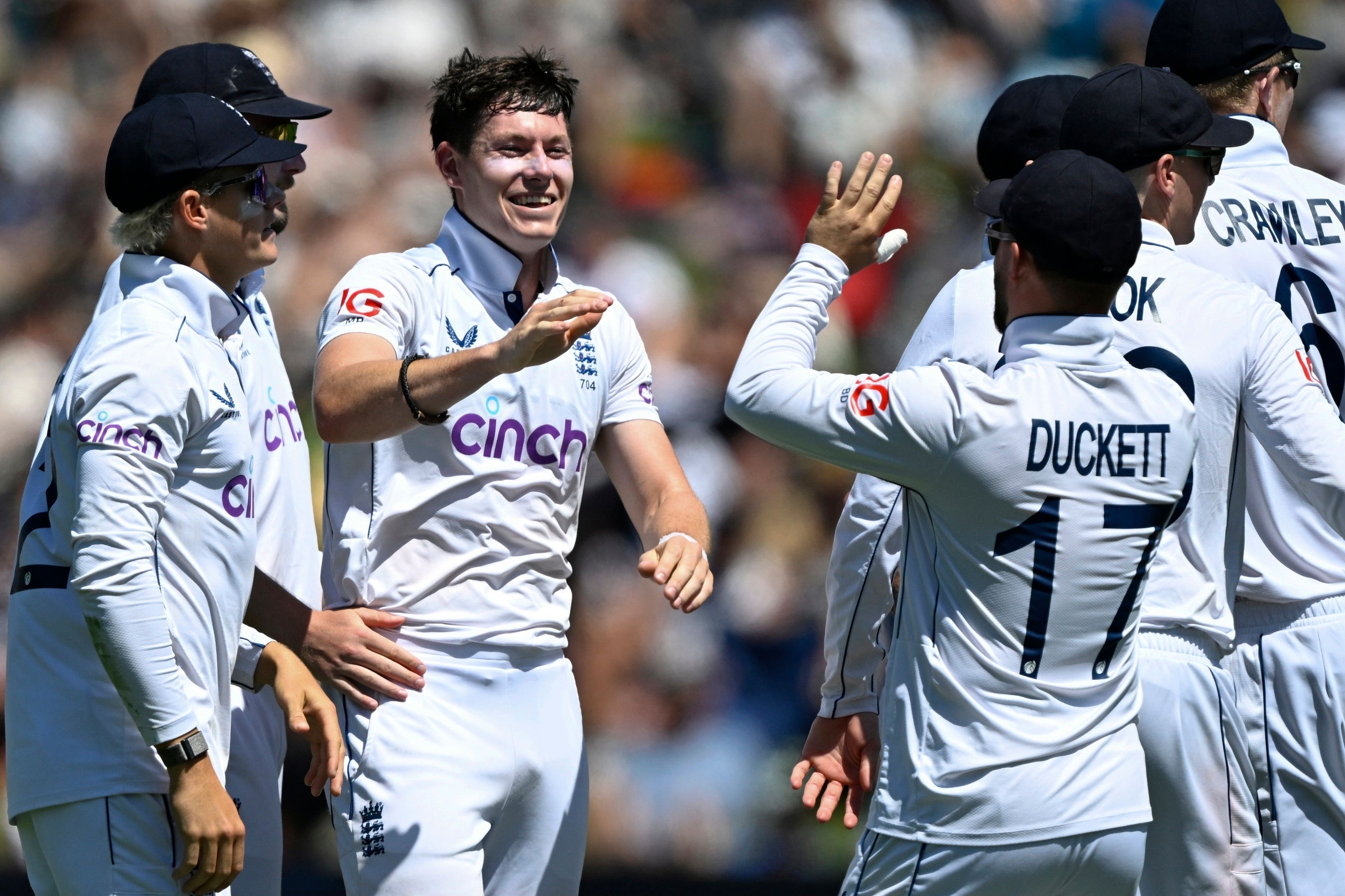 England bowler Matthew Potts, centre, is congratulated by teammates after taking the wicket of New Zealand’s Tom Latham (Andrew Cornaga/Photosport/AP)