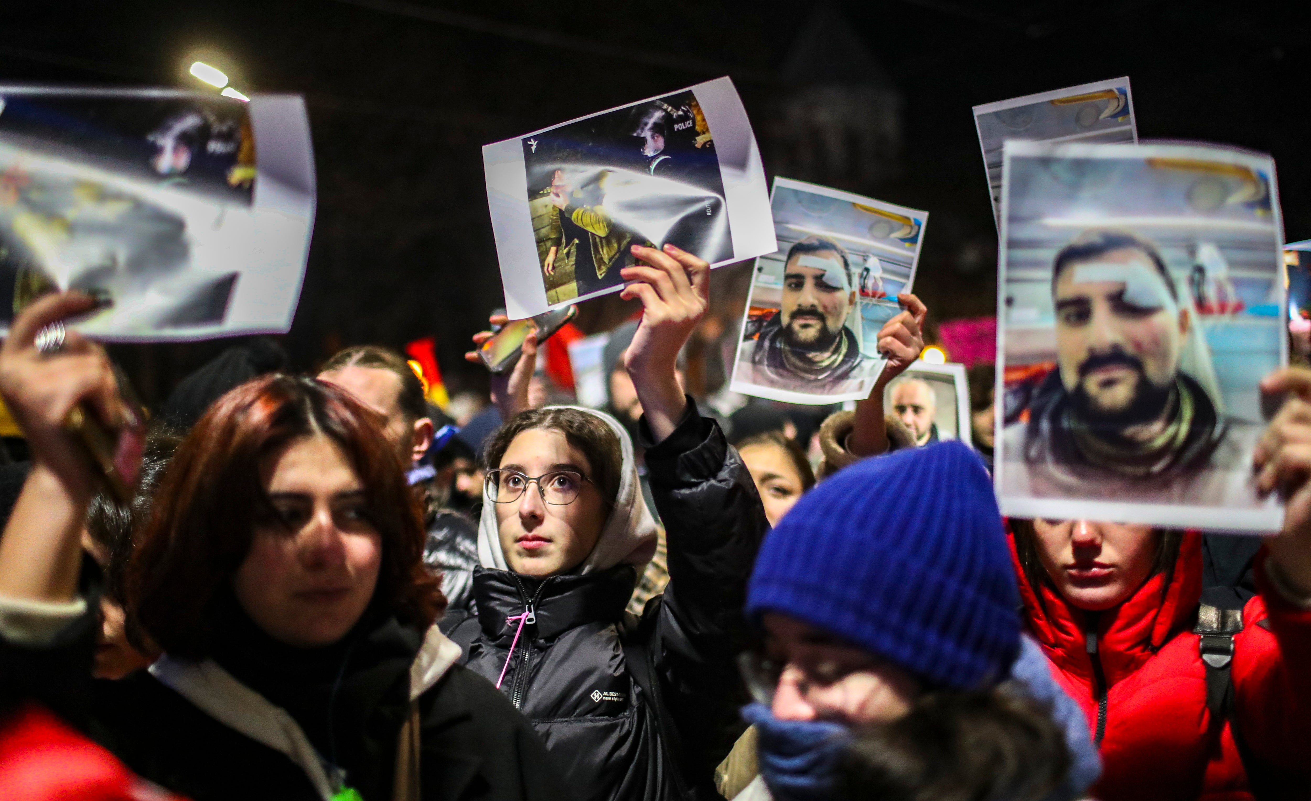 Supporters of the Georgian opposition hold portraits of people injured at rallies