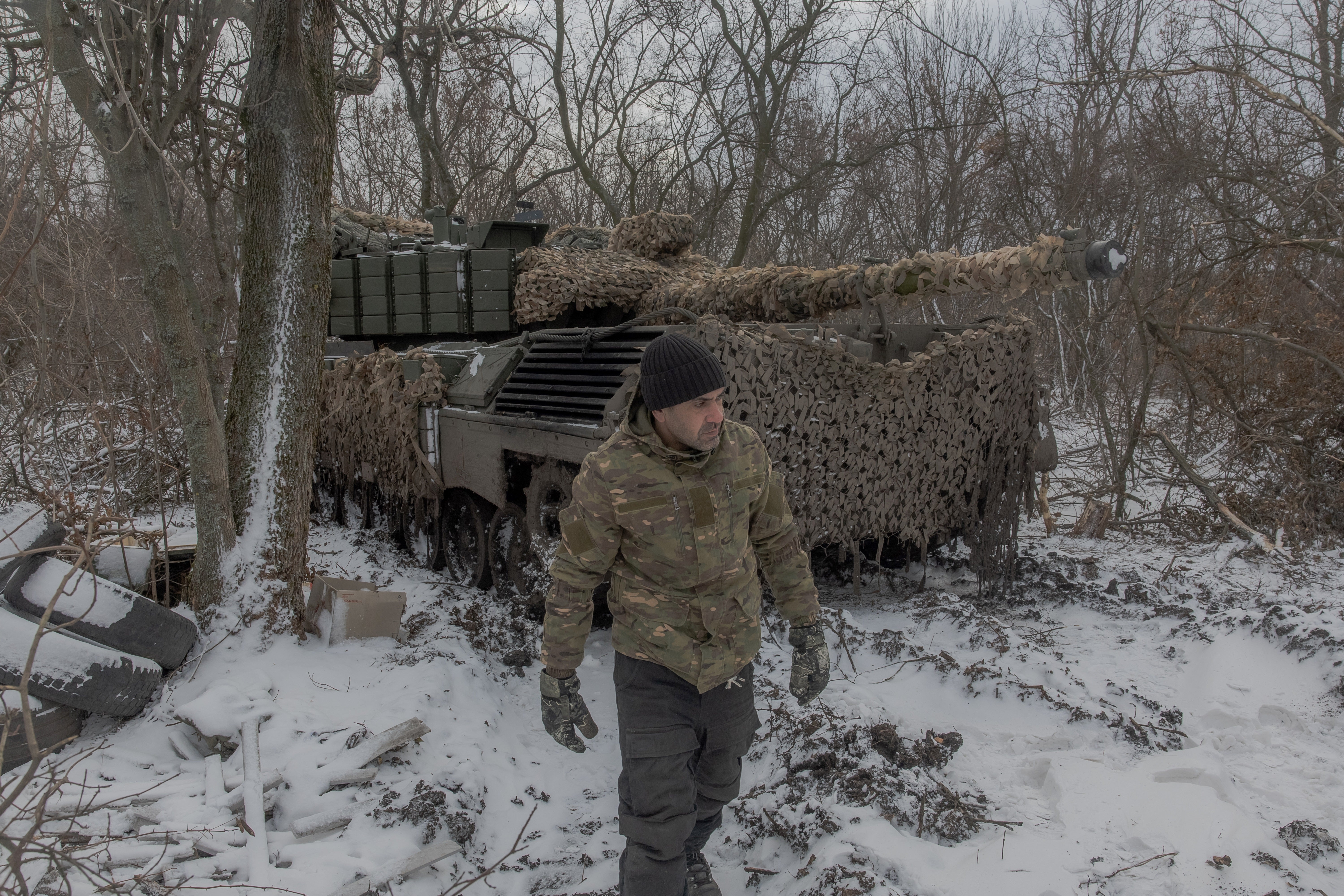 A Ukrainian tank crew member of the 68th Jaeger Brigade walks next to a Leopard 1A5 tank at the position where they take a break in fighting