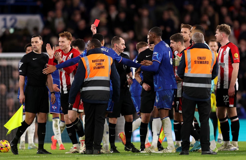 Referee Peter Bankes shows a red card to Cucurella