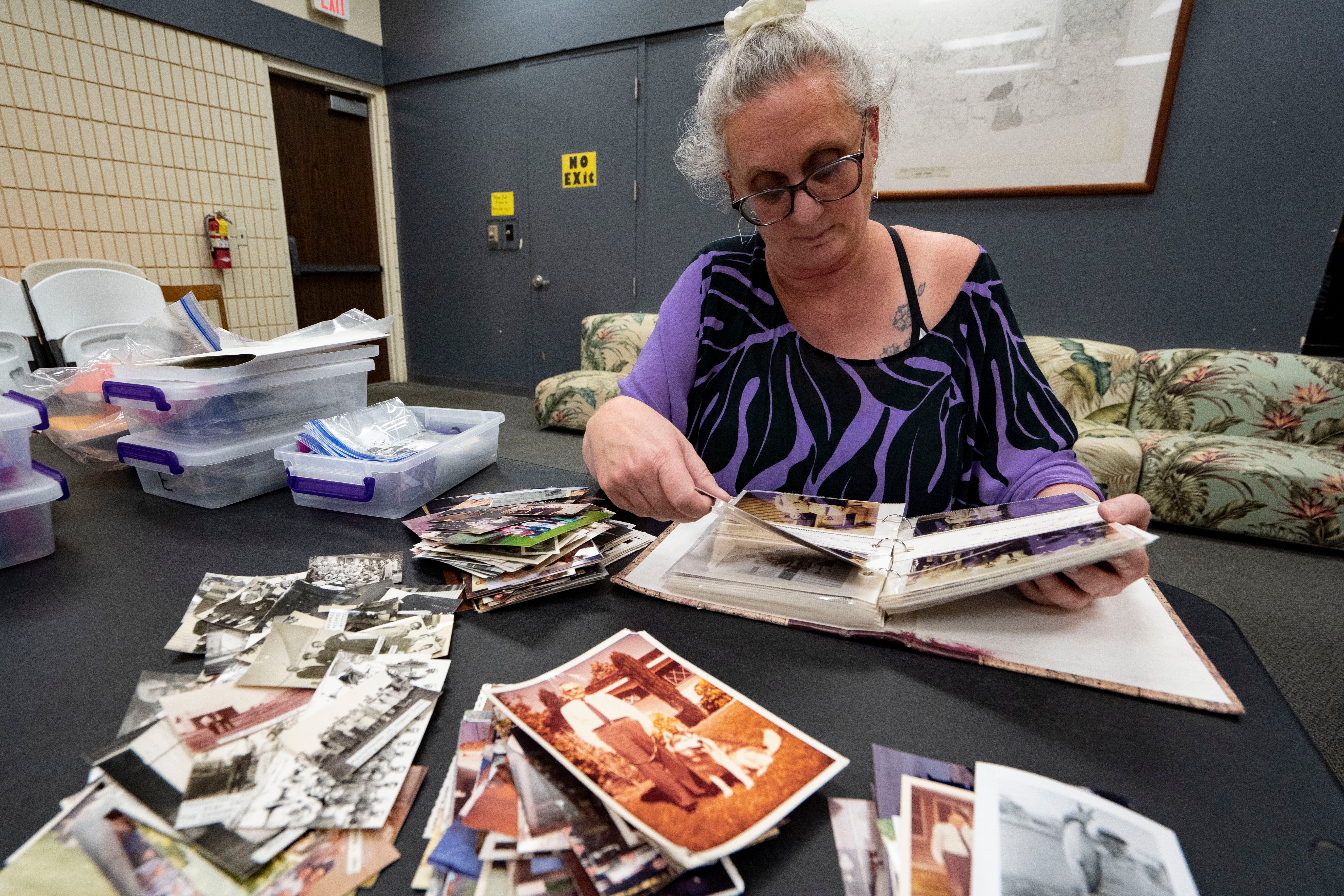 Pam Walton flips through an album containing photographs of ‘Two by Twos’ members and ministers