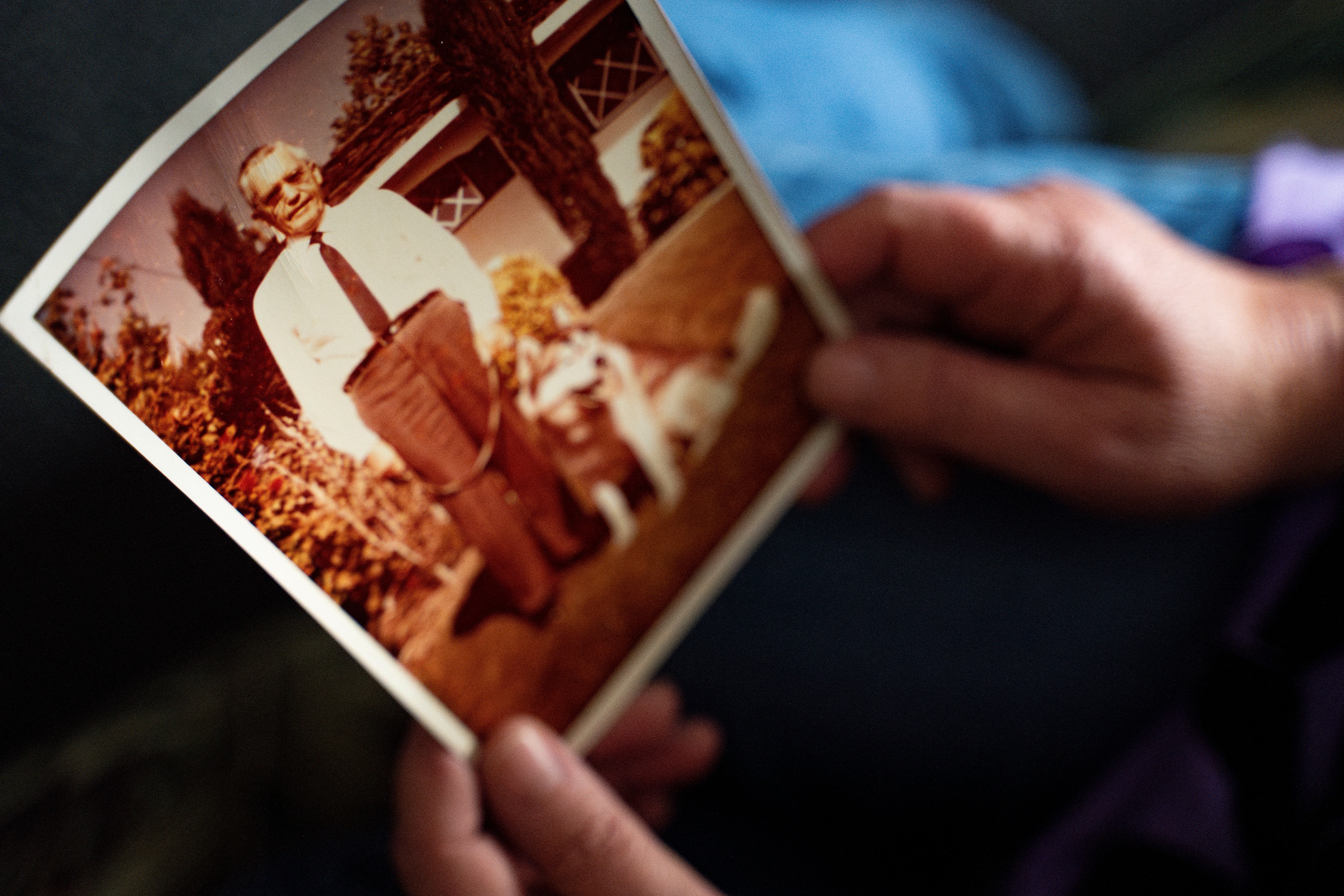 Pam Walton, a former ‘Two by Twos’ sect member who helps track movements of allegedly predatory members through photographs and documents, holds a photograph of a deceased spiritual leader of the sect at a library Monday, Dec. 9, 2024, in Wailea, Hawaii