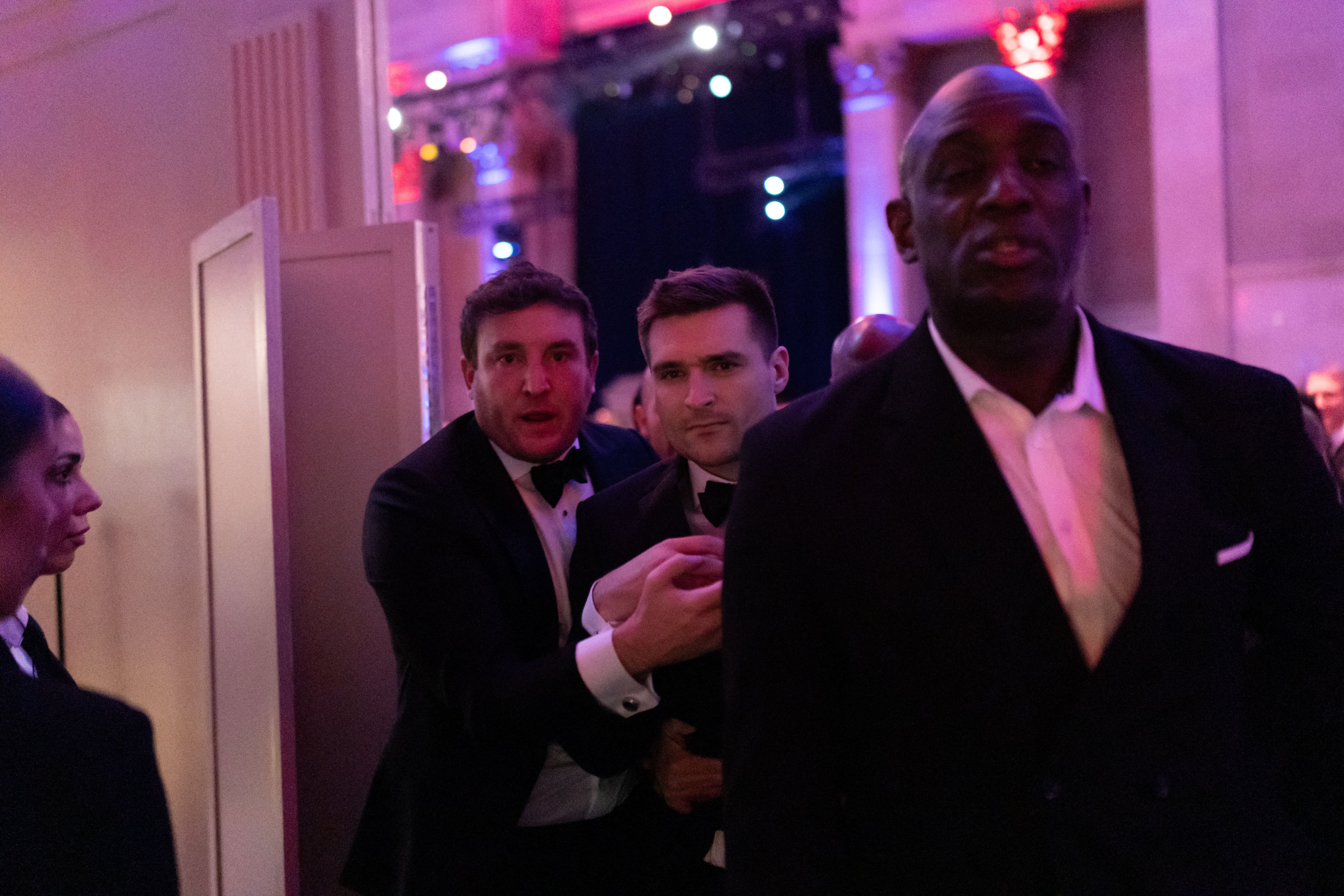 Alex Bruesewitz (center) is escorted backstage after collapsing on stage