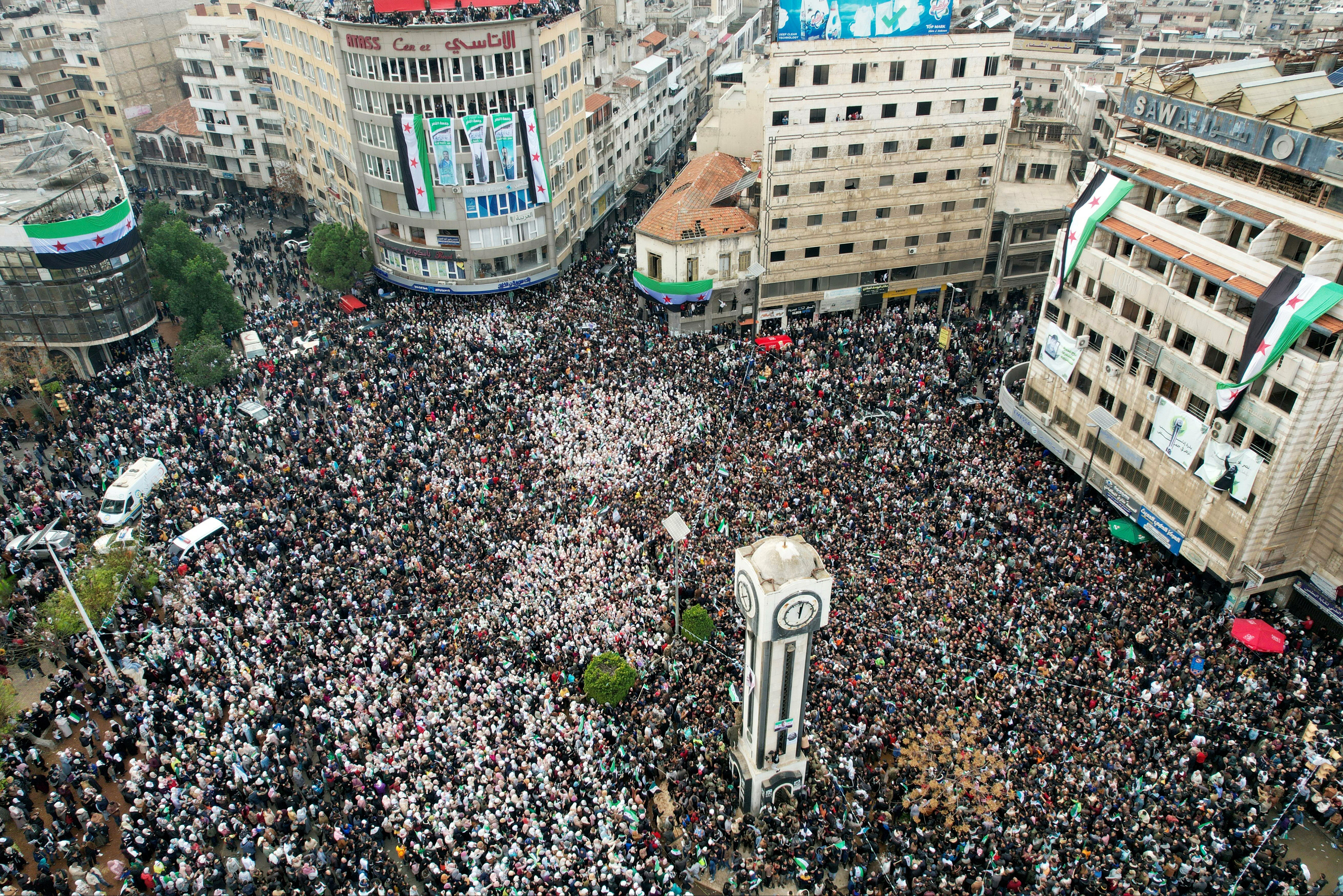 Syrians around the Clock Tower in the central city of Homs as they celebrate the fall of Bashar al-Assad