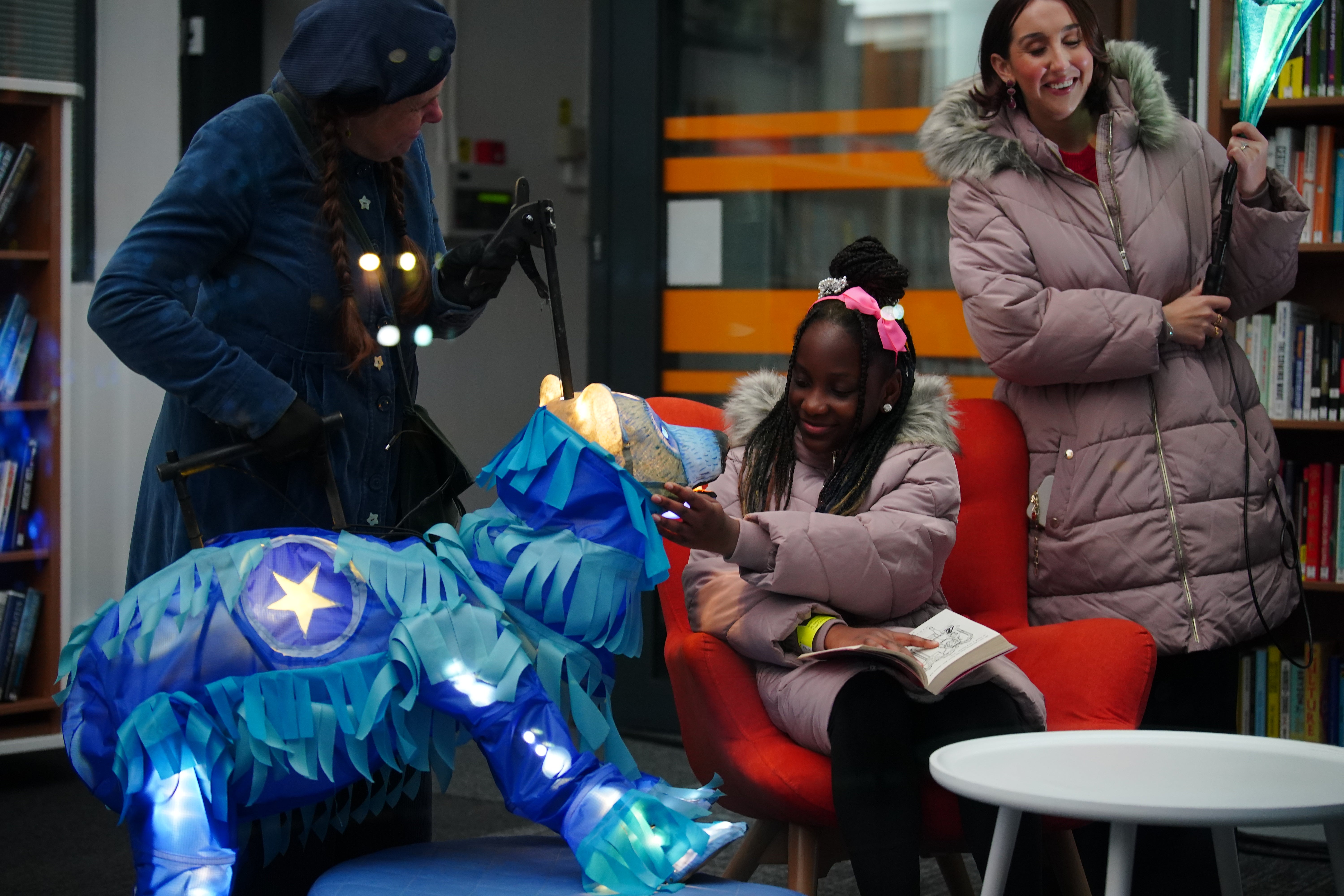 Fundraiser Alex McCormick (right) watching Pearl Ogunyadeka, 10, reading a book inside Spellow Community Hub and Library in Walton, Liverpool, ahead of its reopening after it was torched during riots on County Road in Augus