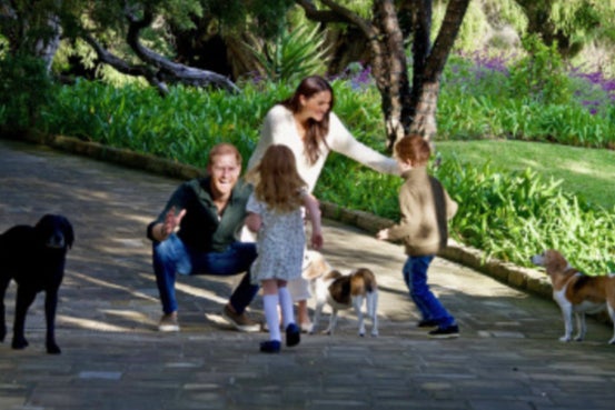 The photo with Archie, 5, and Lilibet, 3, shows the children from behind as they run toward their parents